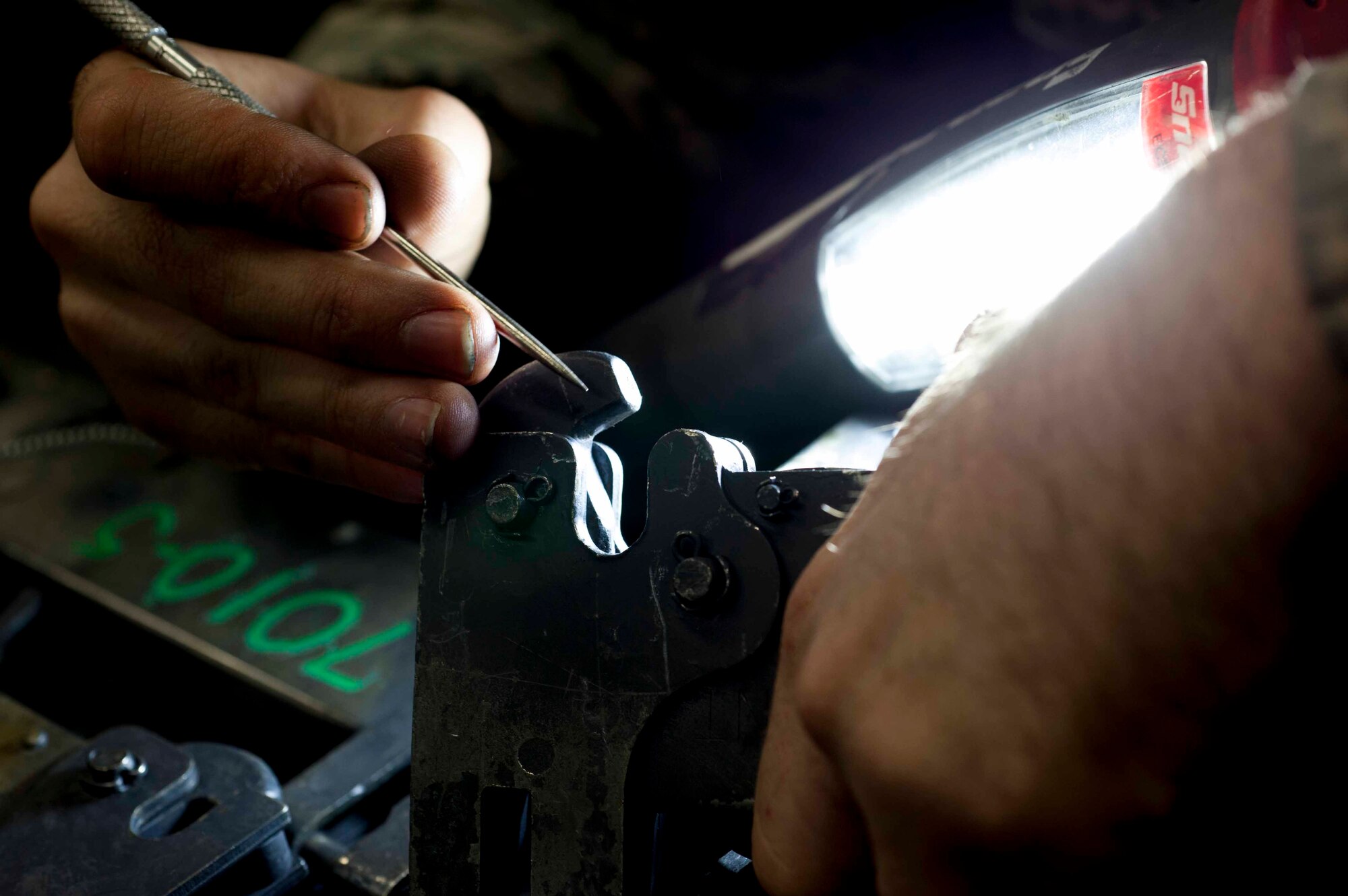 Airman 1st Class Cody Bryson, 5th Munitions Squadron armament team member, removes rust from a B-11 shackle on Minot Air Force Base, N.D., Feb. 3, 2015. B-11 shackles are used to hold weapons in place on bomb racks. (U.S. Air Force photo/Airman 1st Class Sahara L. Fales)