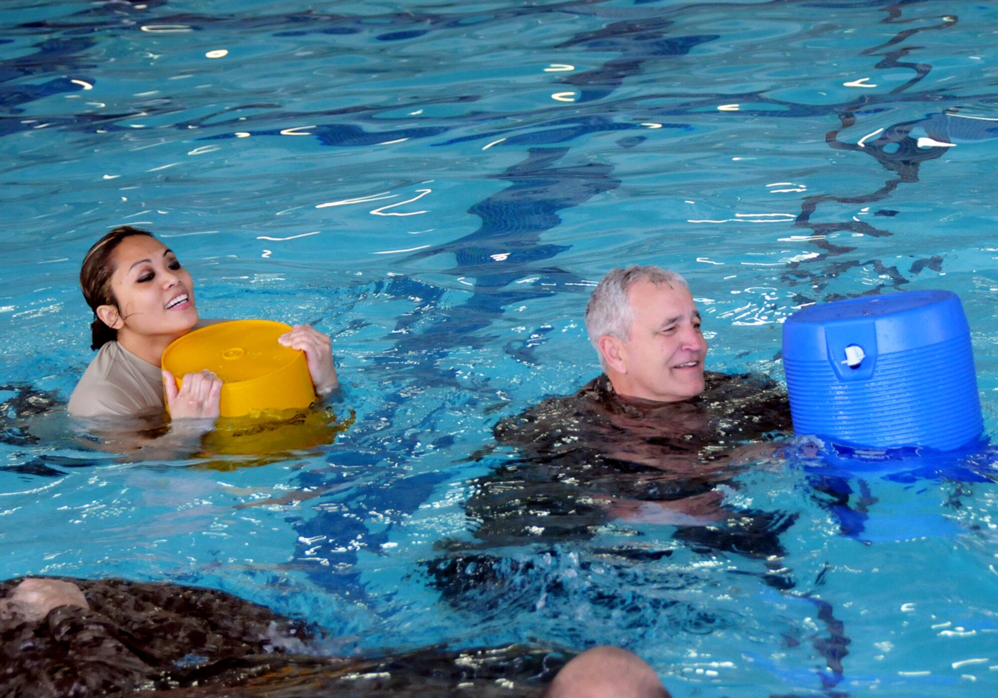 Staff Sgt. Jade Bohling, left, and Staff Sgt. Patrick Hilberling assigned to the 138th Civil Engineering Squadron (CES), participate in a basic water survival course during their unit training assembly Feb. 8, 2015, at the Claremore Super Recreation Center, Claremore, Okla.  The goal of the training was to not only teach water survival skills, but also foster teamwork and build a sense of comradery among CES airmen.    (U.S. National Guard photo by Tech. Sgt. Roberta A. Thompson/Released)