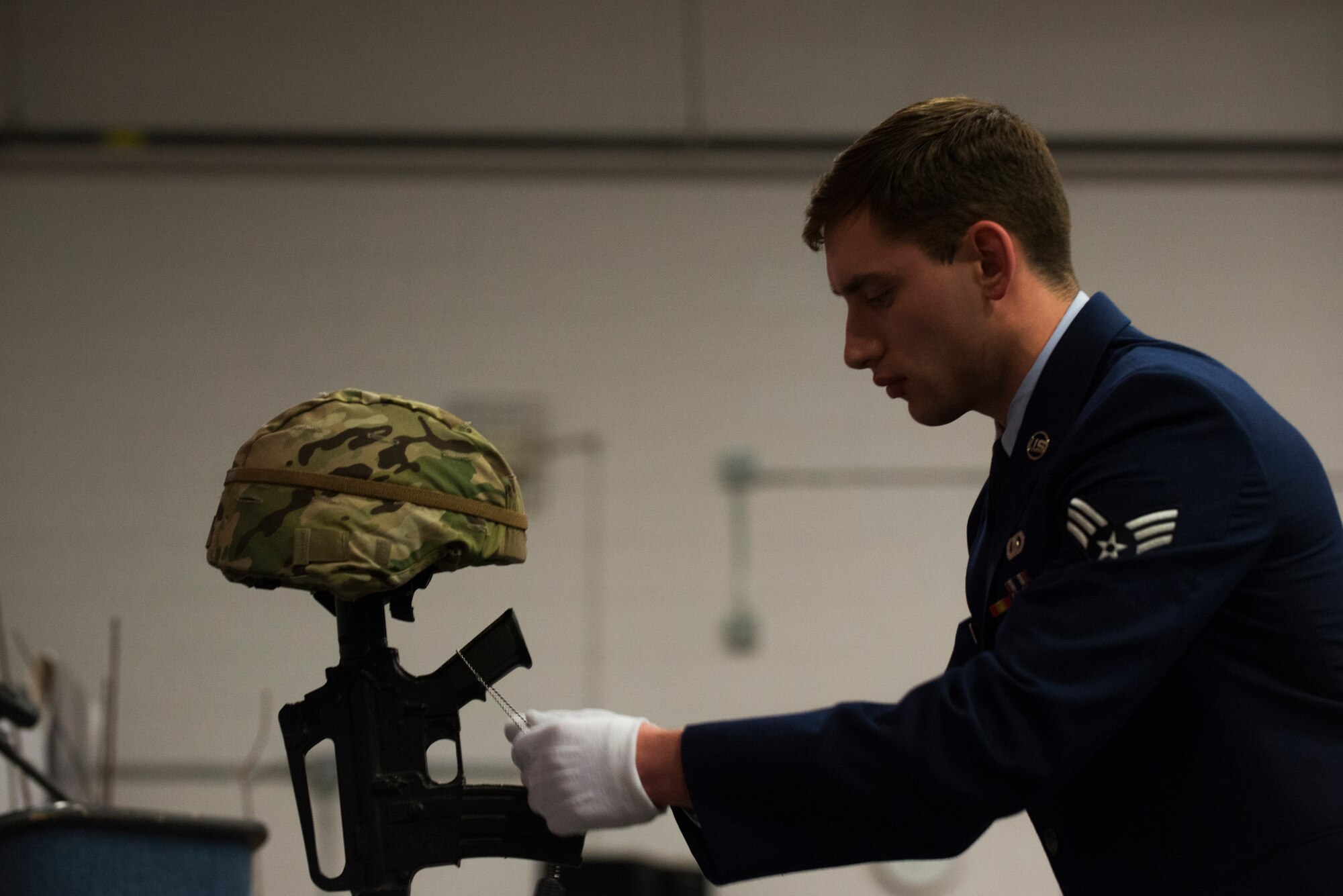 U.S. Air Force Senior Airman Casey Ogden, 23d Operations Support Squadron air traffic controller, places dog tags on a Fallen Warrior memorial during the 2014 Annual Awards Ceremony Feb. 6, 2015, at Moody Air Force Base, Ga. The memorial stood as a remembrance of Airmen from the 23d Wing and 93d Air Ground Operations Wing who were killed in action. (U.S. Air Force photo by Airman 1st Class Dillian Bamman/Released)