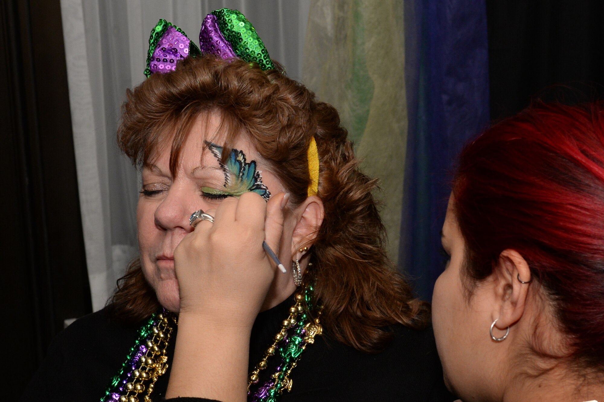 Kay White, Outdoor Recreation assistant supervisor, gets a design painted on her face by a makeup artist during the Mardi Gras event 
at Fort Eustis, Va., Feb. 6, 2015. Mardi Gras is traditionally a two-week celebration through “Fat Tuesday” leading up to “Ash Wednesday” and the beginning of Lent. (U.S. Air Force photo by Staff Sgt. Teresa J. Cleveland/Released)
