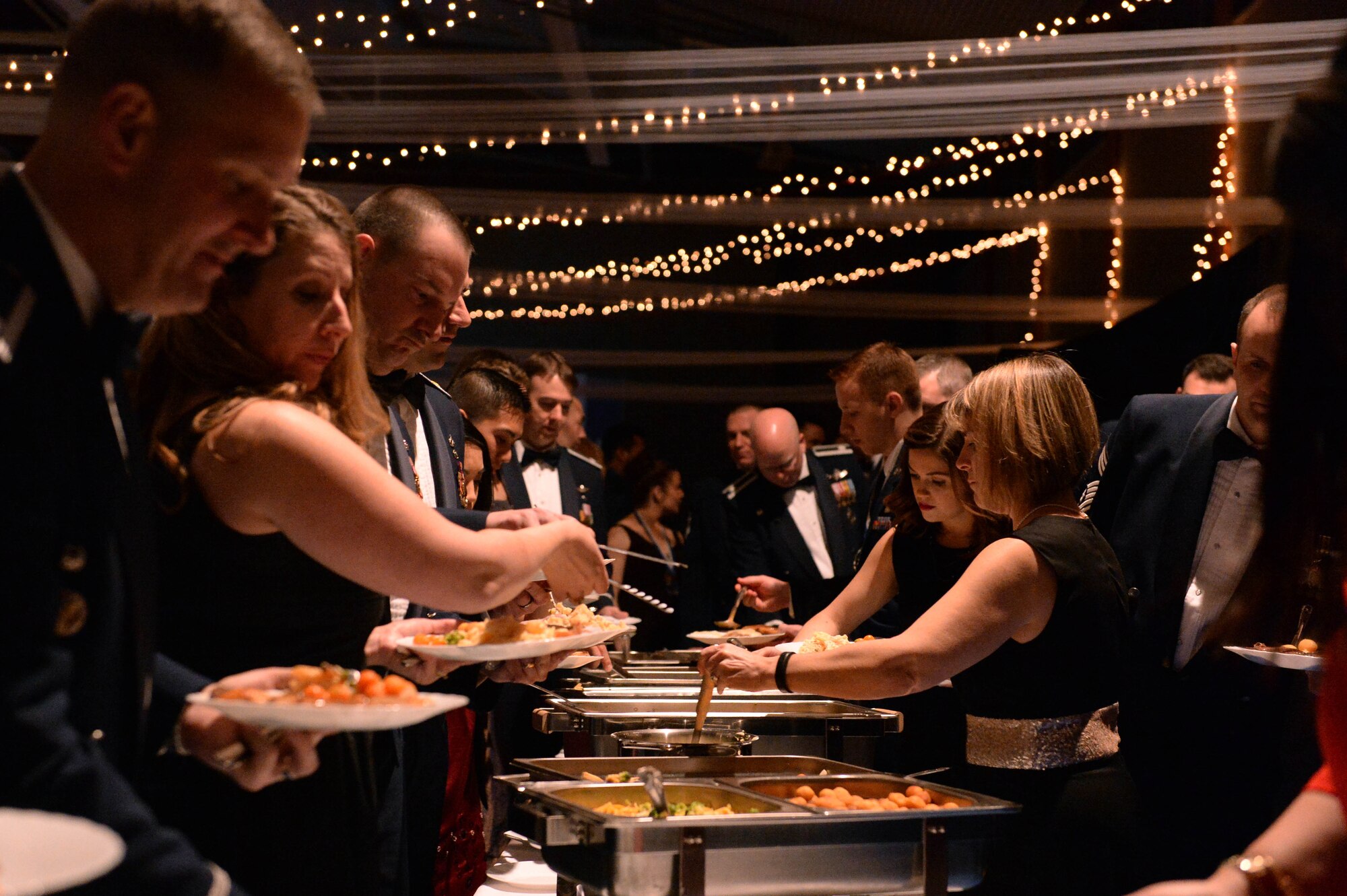 Spangdahlem community members receive their meals during the 52nd Fighter Wing 2014 Annual Awards Banquet at the Skelton Memorial Fitness Center at Spangdahlem Air Base, Germany, Feb. 7, 2015. The Zum Holtzwurm restaurant and Club Eifel staff members offered their catering services to feed the guests at the ceremony. (U.S. Air Force photo by Airman 1st Class Timothy Kim/Released)
