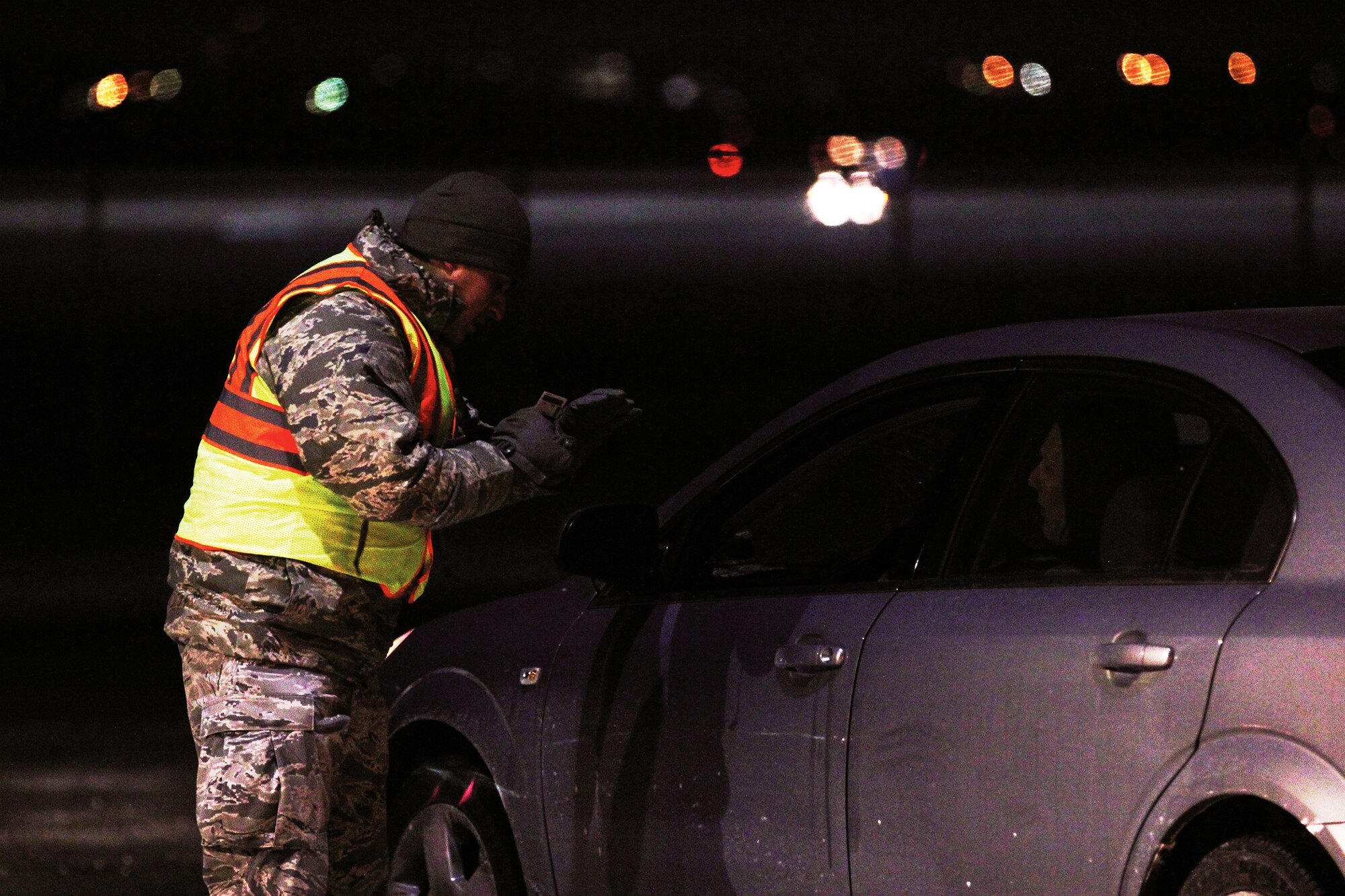 WRIGHT-PATTERSON AIR FORCE BASE, Ohio – Staff Sgt. Steve Fuentes, 445th Security Forces Squadron, checks a 445th Airlift Wing reservist’s common access card at Gate 26A during the Jan. 11, 2015 445th Airlift Wing unit training assembly. The temperature at the time was 4 below zero. (U.S. Air Force photos/Tech. Sgt. Patrick O'Reilly)