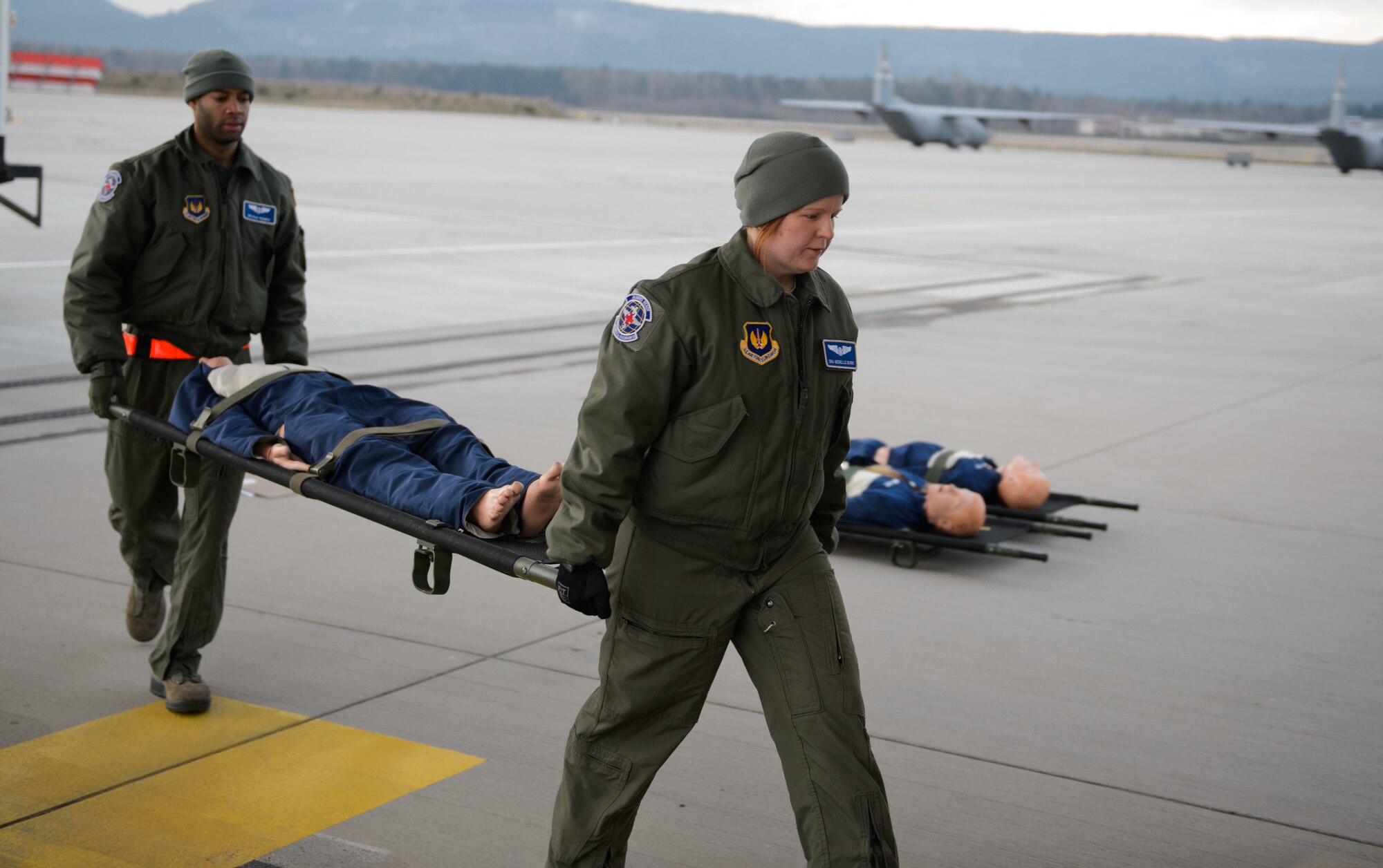 Senior Airman Kyle Pacheco, left, and Senior Airman Michelle Burns, 86th Aeromedical Evacuation Squadron ground team members, carry a mannequin onto a C-130J Super Hercules at Ramstein Air Base, Germany, Feb. 6, 2015. Pacheco and Burns ensure the aeromedical evacuation crew setting up the C-130 is efficient and effective by augmenting them. (U.S. Air Force photo/Senior Airman Armando A. Schwier-Morales) 