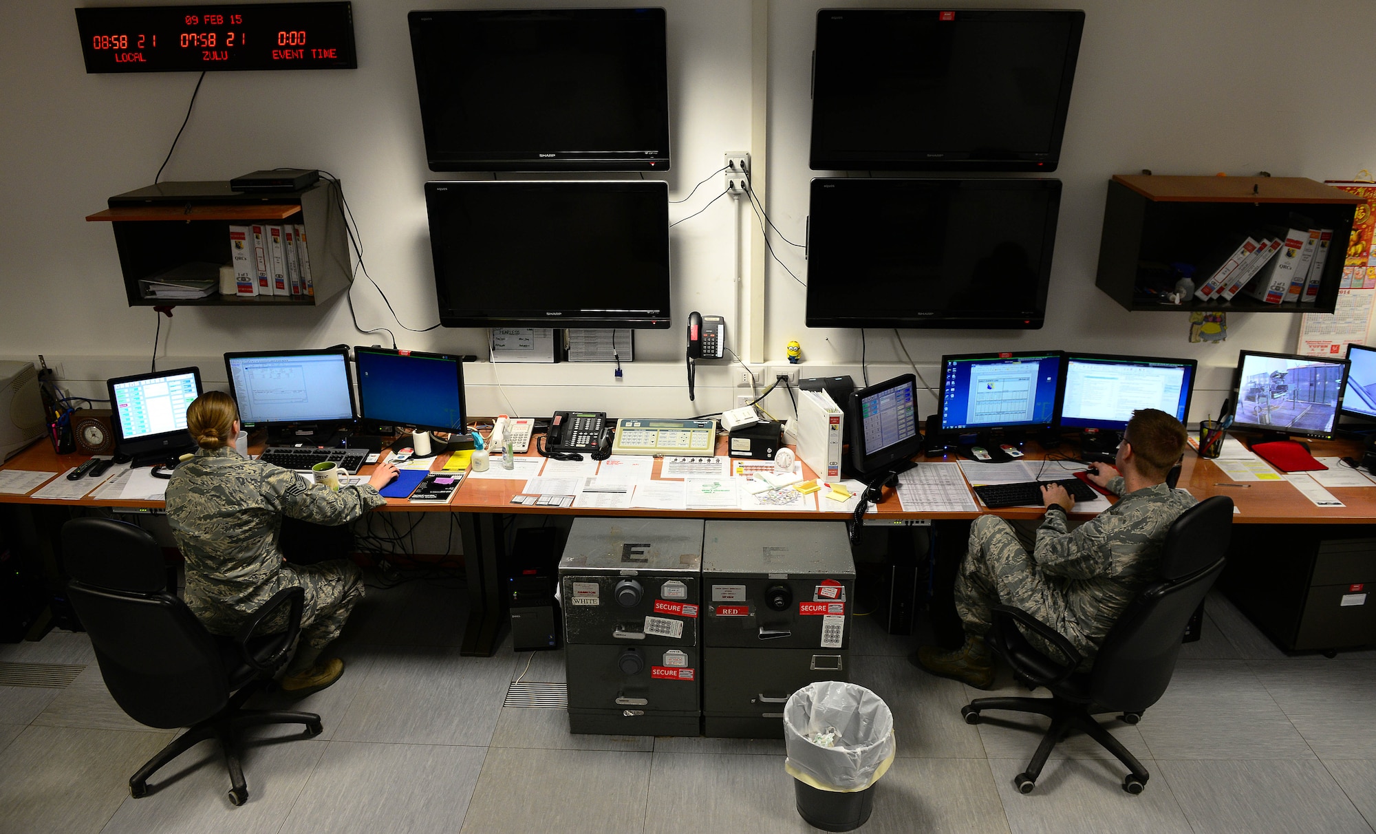 U.S. Air Force emergency actions controllers from the 31st Fighter Wing Command Post check email notifications during a 12-hour work shift, Feb. 9, 2015, at Aviano Air Base, Italy. Command Post Airmen receive daily phone calls that include Red-Cross notifications, in-flight emergencies and vehicle accidents. (U.S. Air Force photo by Senior Airman Matthew Lotz/Released)