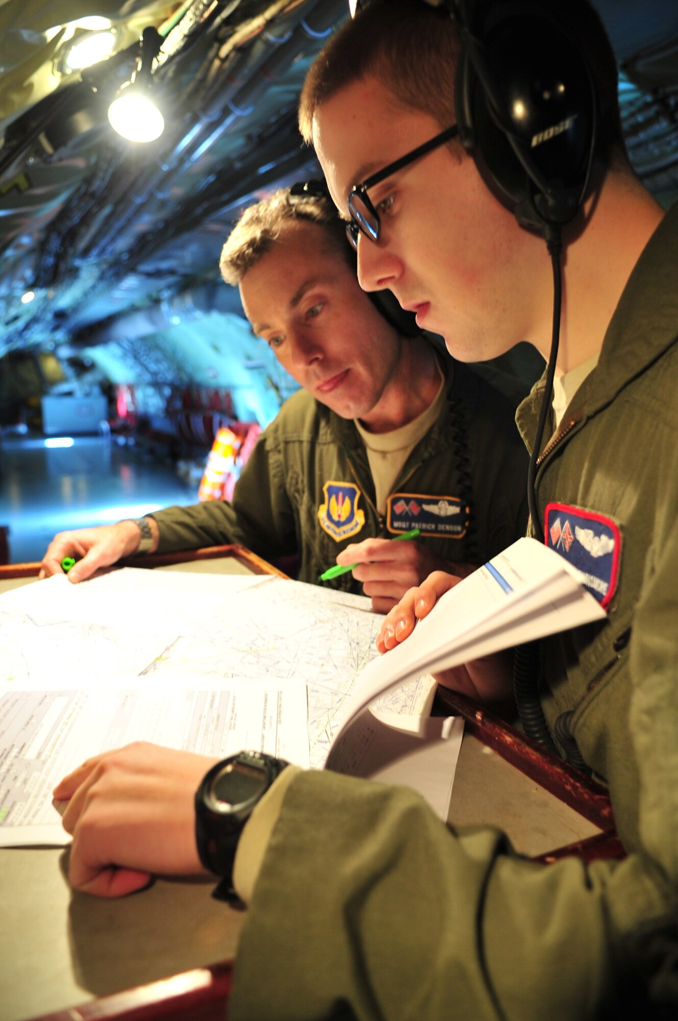 U.S. Air Force Airman 1st Class Jacob P. Dunsmore, right, 351st Air Refueling Squadron boom operator from Chattanooga, Tenn., looks at charts with U.S. Air Force Master Sgt. Patrick Denson, 100th Operations Group boom operator, during a training mission, Feb. 25, 2014. Dunsmore earned the Square D Spotlight for exhibiting the Air Force Core Value of excellence in all we do. (U.S. Air Force photo by Senior Airman Christine Griffiths/Released) 