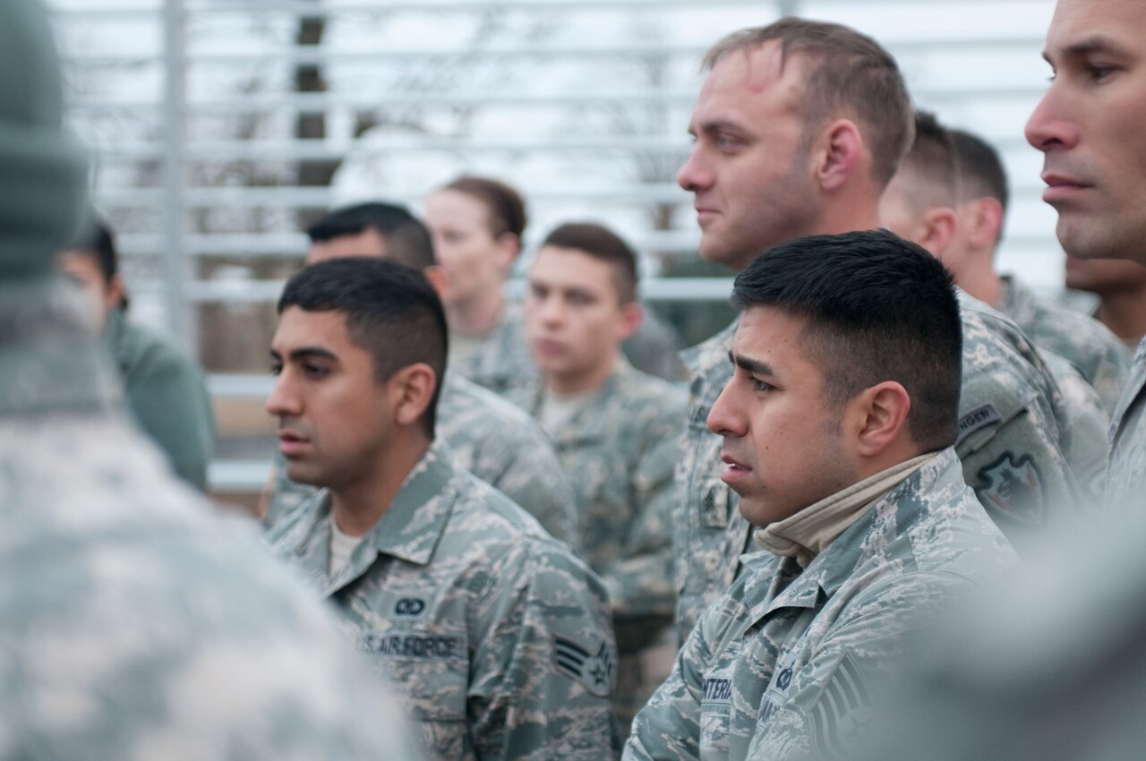 Fraternal twins Air Force Tech. Sgt. Matthew Renteria and Air Force Senior Airman Michael Pineda listen to a briefing before the obstacle course portion of the Texas Military Forces Best Warrior Competition at Camp Swift near Bastrop, Texas, Feb. 5, 2015. U.S. Army photo by Spc. Michael Giles