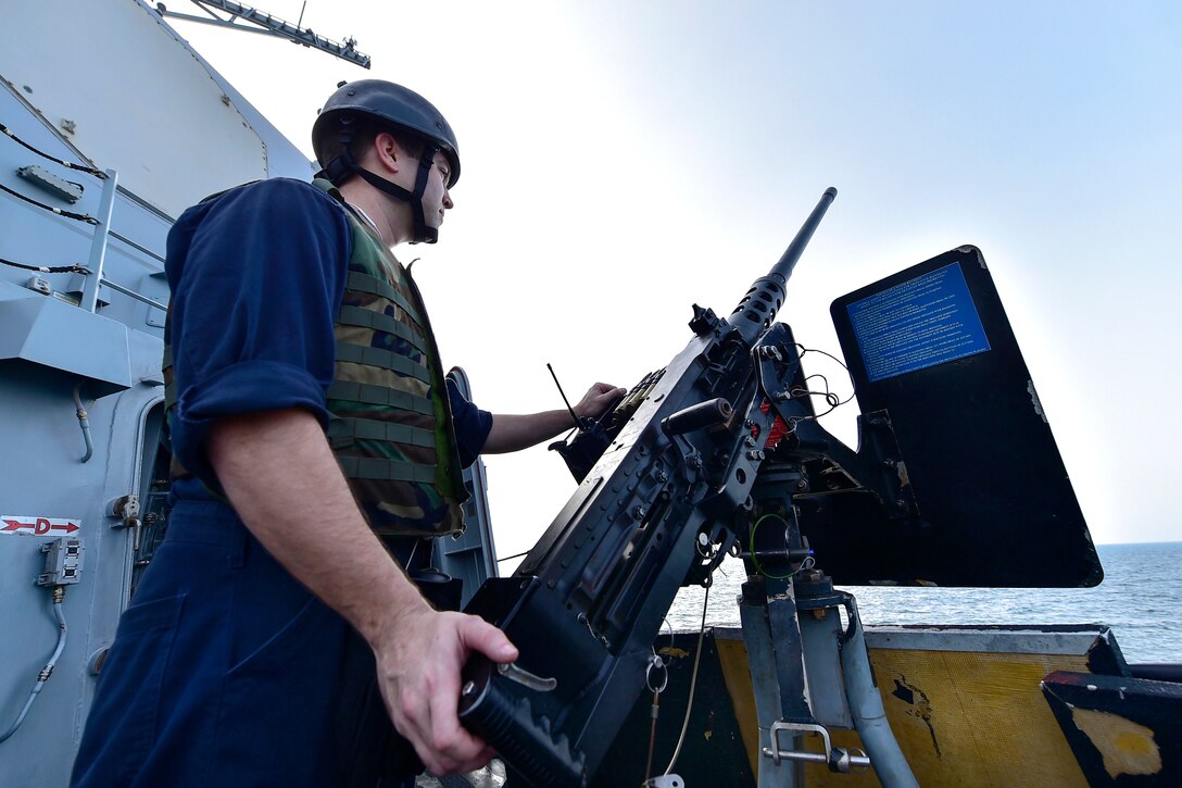 U.S. Navy Petty Officer 2nd Class Andrew Thayer mans an M2HB .50-caliber machine gun aboard the guided-missile destroyer USS Gridley in the U.S. 5th Fleet area of operations, Jan. 31, 2015. Thayer is a fire controlman.