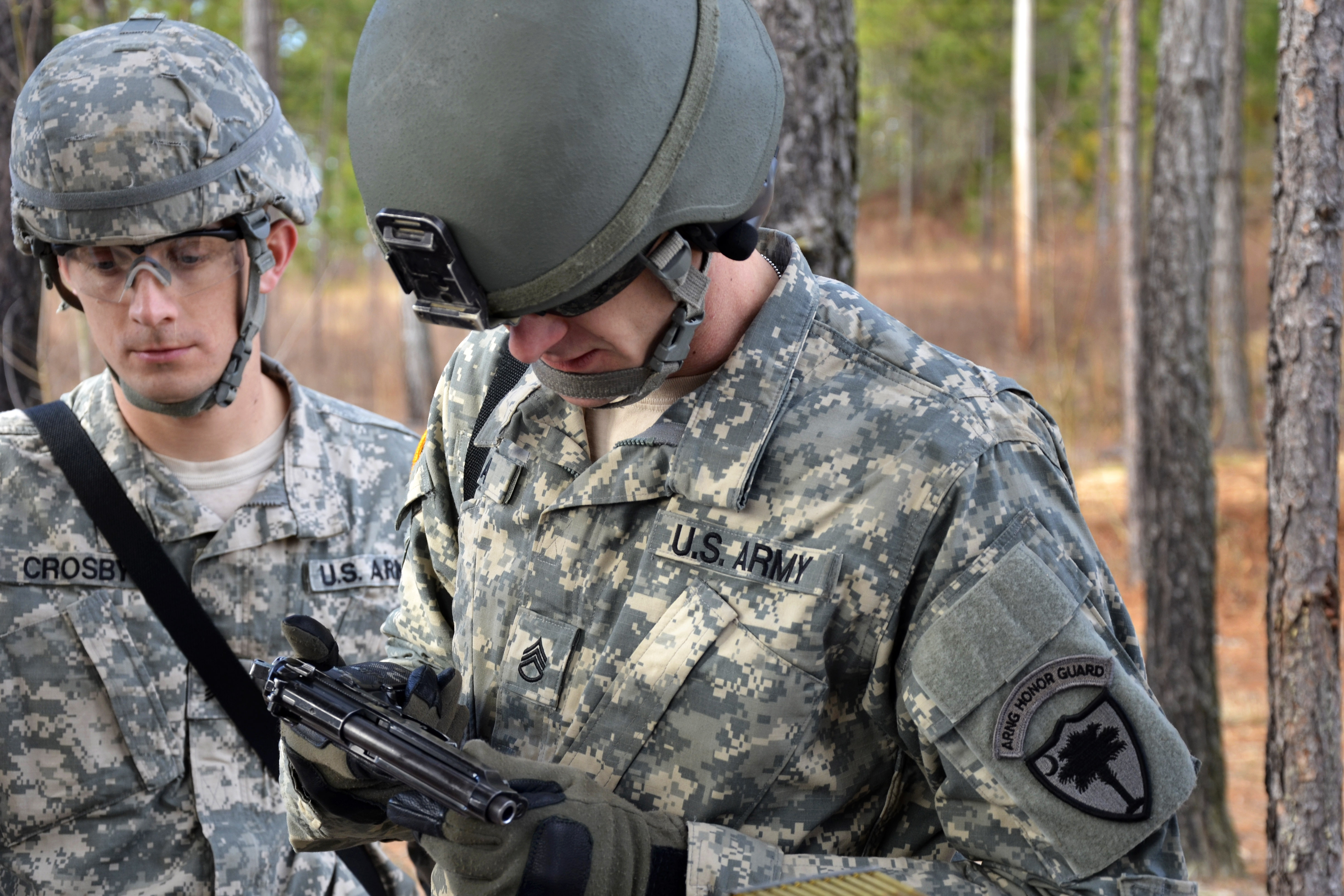 Army Staff Sgt. Christopher Dean, foreground, is issued an M9 Beretta ...