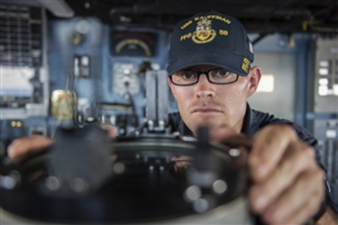 U.S. Navy Ens. Karl Ankersen reads the ship's bearing aboard the guided-missile frigate USS Kauffman in the Carribbean Sea, Feb. 4, 2015. The Ankersen is an electrical officer on the Kauffman.