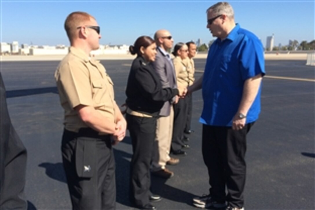 Deputy Defense Secretary Bob Work shakes hands with service members as he prepares to depart Naval Air Station North Island, San Diego, Feb. 10, 2015. While in San Diego, Work attended the U.S. Naval Institute's 2015 Western Conference and Exposition, and later visited the Navy’s newest mobile landing platform under construction.