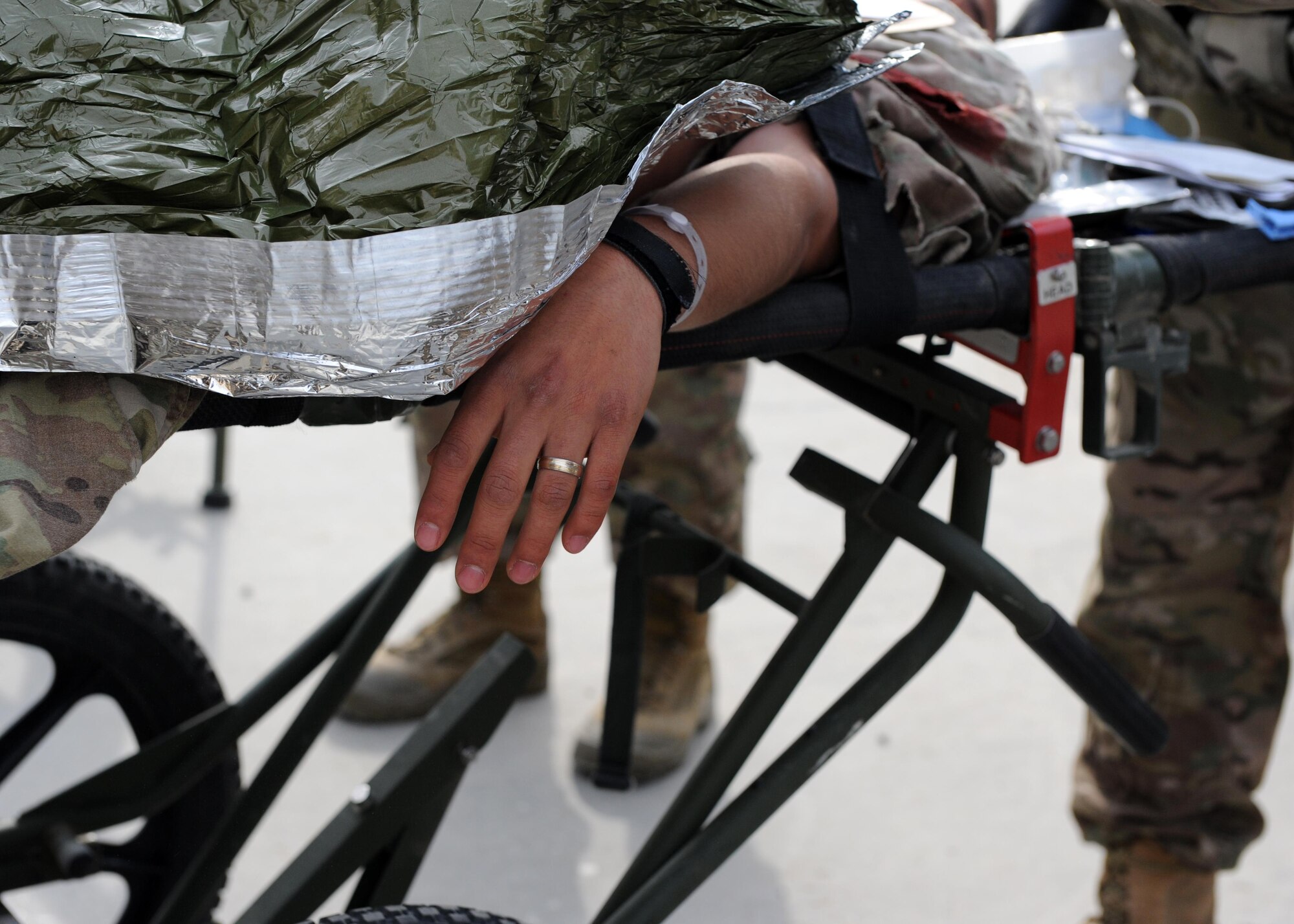 A simulated patient lies on a litter as members of the 455th Expeditionary Medical Group prepare to transport him to the Craig Joint Theater Hospital emergency room during a base exercise Feb. 6, 2015 at Bagram Airfield, Afghanistan. The exercise tested the defensive posture and emergency response preparedness of U.S. and coalition forces here. (U.S. Air Force photo by Staff Sgt. Whitney Amstutz/released)