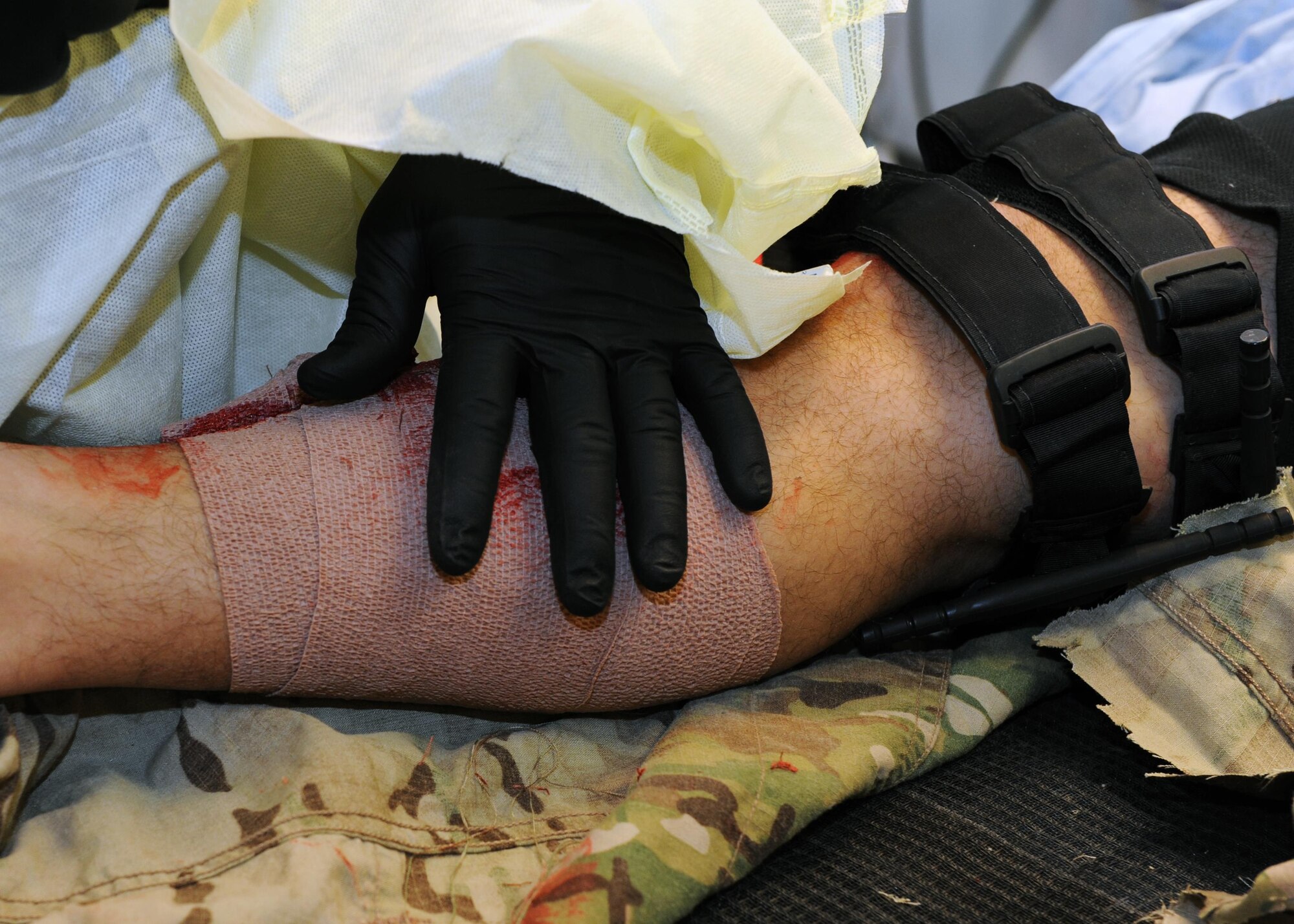A U.S. Air Force Airman assigned to the 455th Expeditionary Medical Group assesses the simulated wounds of a patient during a base exercise Feb. 6, 2015 at Bagram Airfield, Afghanistan. The exercise tested the defensive posture and emergency response preparedness of U.S. and coalition forces here. (U.S. Air Force photo by Staff Sgt. Whitney Amstutz/released)