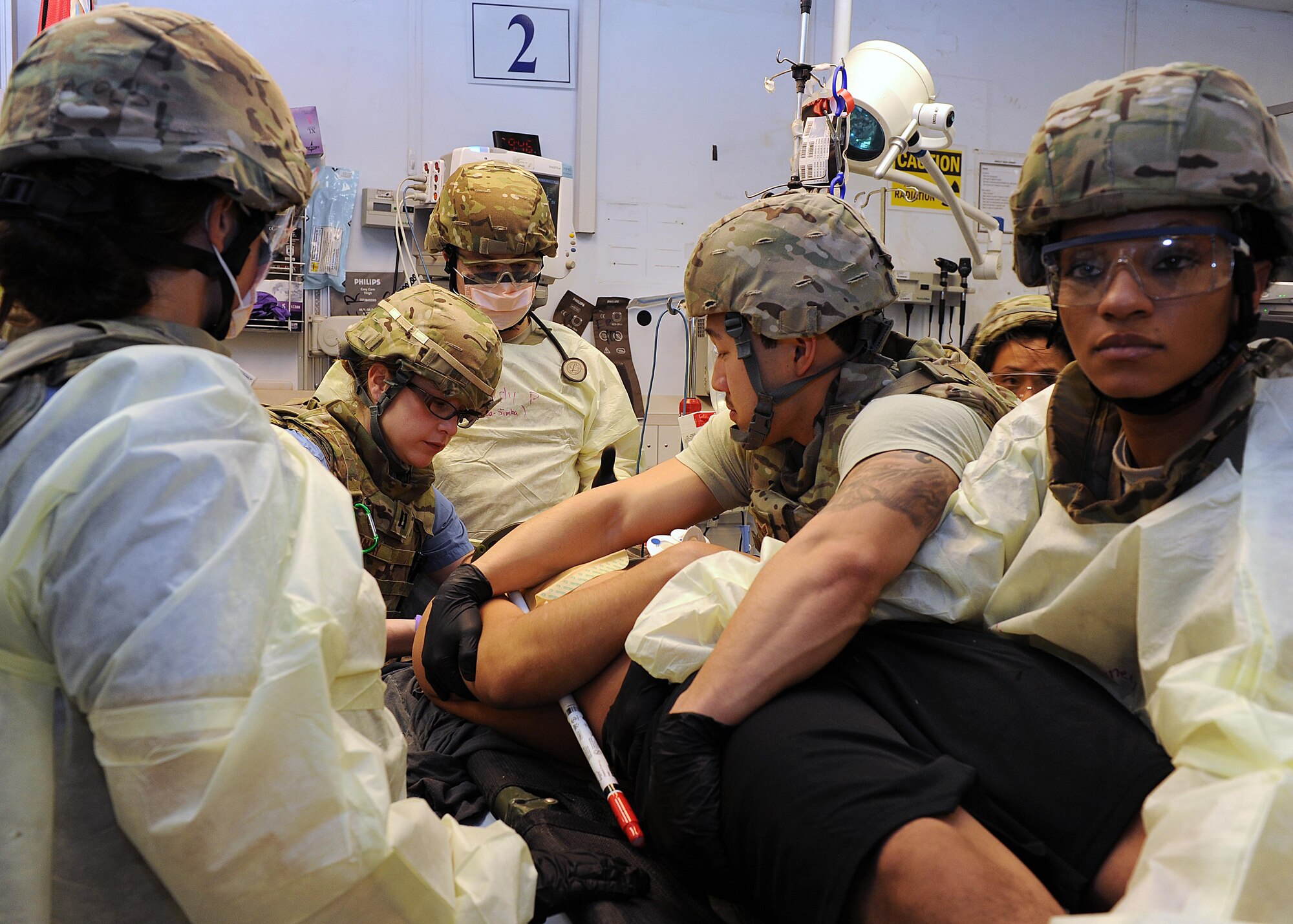 U.S. Air Force Airmen assigned to the 455th Expeditionary Medical Group prepare to transfer a simulated patient from a litter to a patient bed in the emergency room of the Craig Joint Theater Hospital during a base exercise Feb. 6, 2015 at Bagram Airfield, Afghanistan. The exercise tested the defensive posture and emergency response preparedness of U.S. and coalition forces here. (U.S. Air Force photo by Staff Sgt. Whitney Amstutz/released)