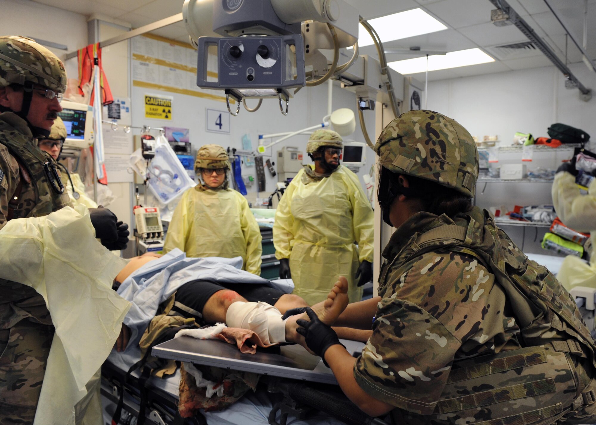 U.S. Air Force Airmen assigned to the 455th Expeditionary Medical Group prepare to transfer a simulated patient from a litter to a patient bed in the emergency room of the Craig Joint Theater Hospital during a base exercise Feb. 6, 2015 at Bagram Airfield, Afghanistan. The exercise tested the defensive posture and emergency response preparedness of U.S. and coalition forces here. (U.S. Air Force photo by Staff Sgt. Whitney Amstutz/released)