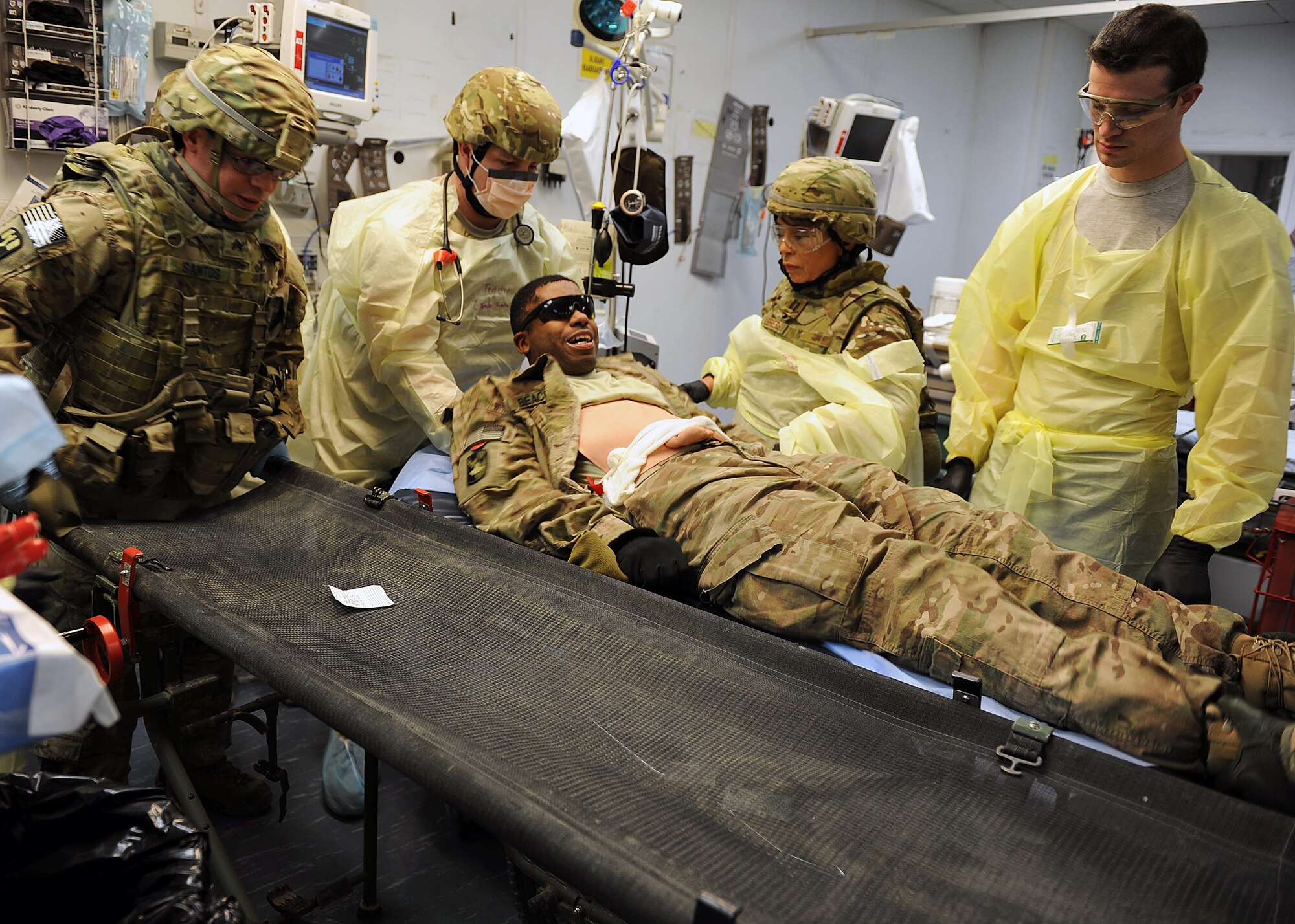U.S. Air Force Airmen assigned to the 455th Expeditionary Medical Group transfer an exercise role-player from a litter to a patient bed in the emergency room of the Craig Joint Theater Hospital during an exercise Feb. 6, 2015 at Bagram Airfield, Afghanistan. The exercise tested the defensive posture and emergency response preparedness of U.S. and coalition forces here. (U.S. Air Force photo by Staff Sgt. Whitney Amstutz/released)