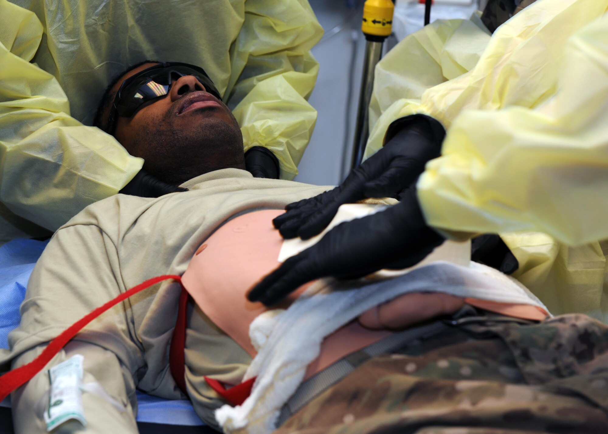 U.S. Air Force Airmen assigned to the 455th Expeditionary Medical Group simulate performing an initial assessment on an exercise role-player in the emergency room of the Craig Joint Theater Hospital during an exercise Feb. 6, 2015 at Bagram Airfield, Afghanistan. The exercise tested the defensive posture and emergency response preparedness of U.S. and coalition forces here. (U.S. Air Force photo by Staff Sgt. Whitney Amstutz/released)