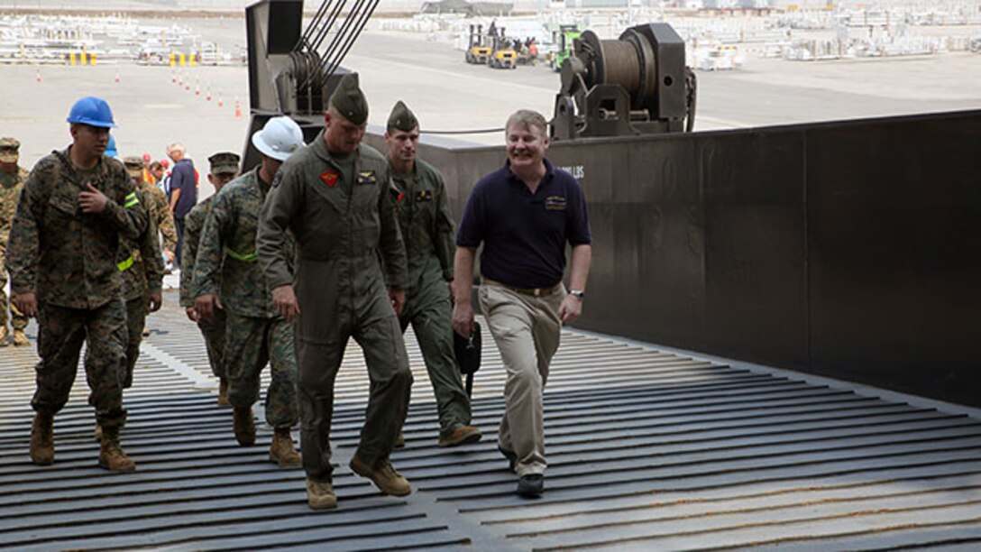 Capt. Don E. Pigott, captain of the Maritime Prepositioning Force ship, USNS Pililaau, welcomes Brig. Gen. Steven Rudder, the commanding general for 1st Marine Aircraft Wing, aboard the ship. Rudder received a tour of the supplies and equipment onboard the ship to be used during Exercise Cobra Gold 2015.
