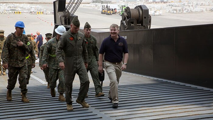 Capt. Don E. Pigott, captain of the Maritime Prepositioning Force ship, USNS Pililaau, welcomes Brig. Gen. Steven Rudder, the commanding general for 1st Marine Aircraft Wing, aboard the ship. Rudder received a tour of the supplies and equipment onboard the ship to be used during Exercise Cobra Gold 2015.
