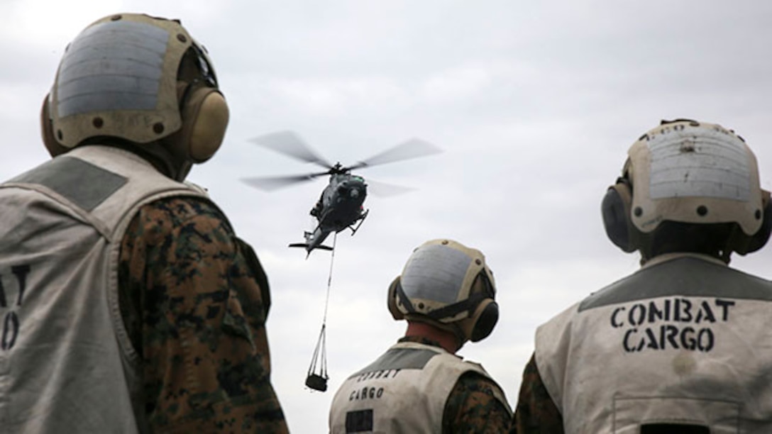 Landing support specialists wait for a UH-1Y Huey attached to Marine Medium Tiltrotor Squadron 262, 31st Marine Expeditionary Unit, to drop off a load of tires during a helicopter support team exercise Feb. 6 on the flight deck of the USS Bonhomme Richard. This was the first time the Marines performed an HST exercise aboard a ship. The Marines are with Combat Logistics Battalion 31, 31st MEU, and are currently deployed in support of the annually-scheduled Spring Patrol of the Asia-Pacific region.