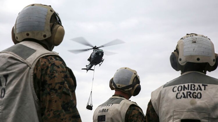 Landing support specialists wait for a UH-1Y Huey attached to Marine Medium Tiltrotor Squadron 262, 31st Marine Expeditionary Unit, to drop off a load of tires during a helicopter support team exercise Feb. 6 on the flight deck of the USS Bonhomme Richard. This was the first time the Marines performed an HST exercise aboard a ship. The Marines are with Combat Logistics Battalion 31, 31st MEU, and are currently deployed in support of the annually-scheduled Spring Patrol of the Asia-Pacific region.
