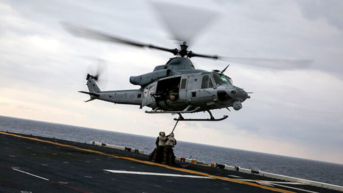 Landing support specialists attach a load of tires to a UH-1Y Huey attached to Marine Medium Tiltrotor Squadron 262, 31st Marine Expeditionary Unit, during a helicopter support team exercise Feb. 6 on the flight deck of the USS Bonhomme Richard. The Marines used a MK-105 cable, also known as the Q-tip, to hook the load onto the bottom of the Huey. The Marines are with Combat Logistics Battalion 31, 31st MEU, and are currently deployed in support of the annually-scheduled Spring Patrol of the Asia-Pacific region.
