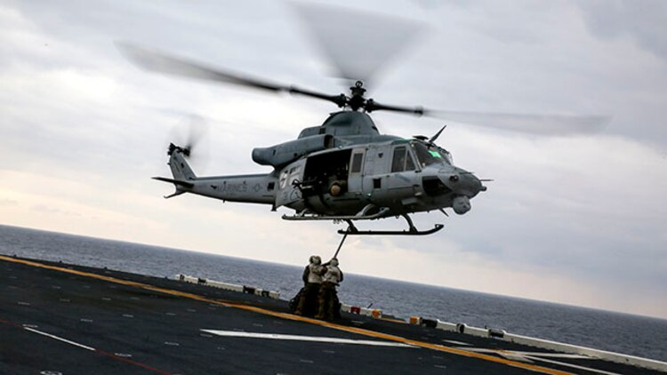 Landing support specialists attach a load of tires to a UH-1Y Huey attached to Marine Medium Tiltrotor Squadron 262, 31st Marine Expeditionary Unit, during a helicopter support team exercise Feb. 6 on the flight deck of the USS Bonhomme Richard. The Marines used a MK-105 cable, also known as the Q-tip, to hook the load onto the bottom of the Huey. The Marines are with Combat Logistics Battalion 31, 31st MEU, and are currently deployed in support of the annually-scheduled Spring Patrol of the Asia-Pacific region.