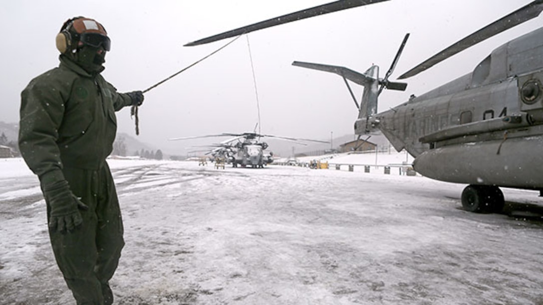 Corporal Adam Lindsey, a crew chief with Marine Heavy Helicopter Squadron 464, manually rotates a CH-53 Super Stallion’s propeller to brush snow and ice off of the blades during their deployment for training exercise aboard Camp Dawson, West Virginia, Jan. 30, 2015. Inclement weather caused the Marines to take extra steps in preparing the helicopters for flight.