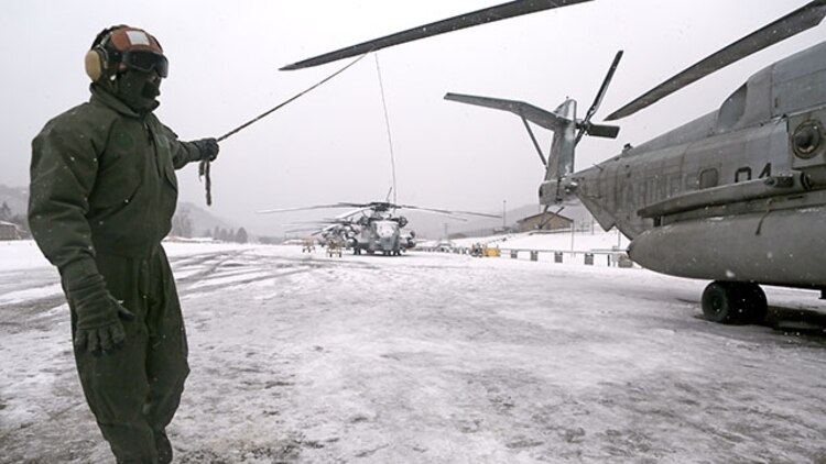 Corporal Adam Lindsey, a crew chief with Marine Heavy Helicopter Squadron 464, manually rotates a CH-53 Super Stallion’s propeller to brush snow and ice off of the blades during their deployment for training exercise aboard Camp Dawson, West Virginia, Jan. 30, 2015. Inclement weather caused the Marines to take extra steps in preparing the helicopters for flight.