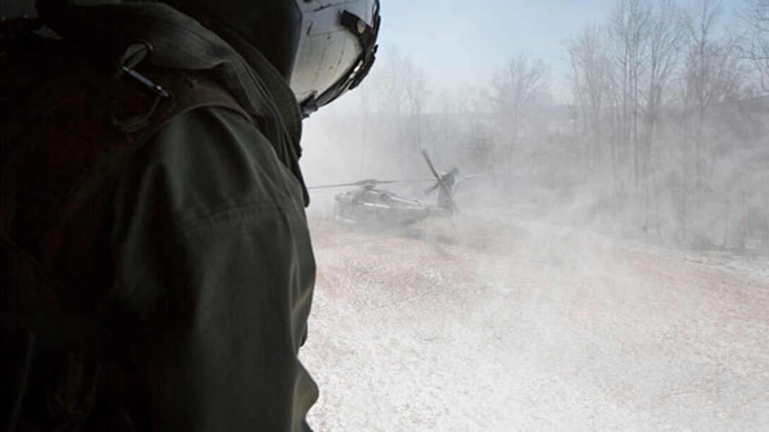 Corporal Adam Lindsey, a crew chief with Marine Heavy Helicopter Squadron 464, looks out of a window on a CH-53 Super Stallion during a confined area landing flight as part of the squadron’s deployment for training exercise aboard Camp Dawson, West Virginia, Jan. 31, 2015. The goal of the DFT is to prepare the squadron to work and effectively accomplish their mission in a different environment than they are used to.