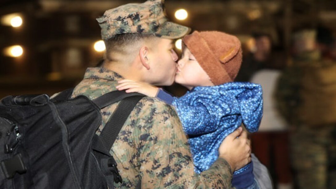 A Marine greets his son during a homecoming event aboard Camp Lejeune, N.C., Jan. 14, 2015. Marines and Sailors with Combat Logistics Battalion-2 returned from a six-month deployment in support of Special Purpose Marine Air-Ground Task Force Crisis Response-Africa. 