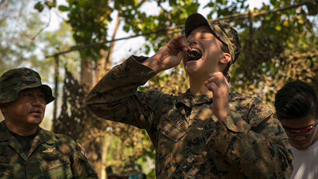 Cpl. Kyleigh M. Porter, from Montross, Va., eats a scorpion Feb. 8 in Ban Chan Krem, Thailand, during exercise Cobra Gold 2015. The Royal Thai Marines demonstrated several jungle survival tactics and asked for U.S. Marine volunteers to participate. Porter is a radio operator with Marine Air Support Squadron 2, Marine Air Control Group 18, 1st Marine Aircraft Wing, III Marine Expeditionary Force.