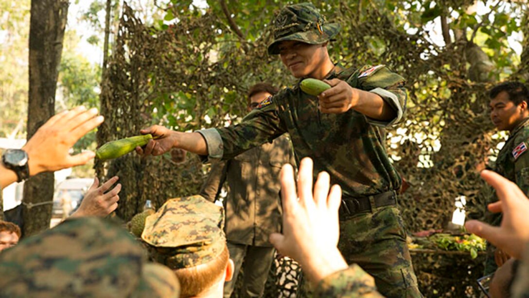 Thinnakorn Pajorn passes fruit to U.S. Marines Feb. 8 at Ban Chan Krem, Thailand, during exercise Cobra Gold 2015. The Royal Thai Marines gave the U.S. Marines a taste of Thailand by sharing fruit commonly found in the jungle. The Marines are with III Marine Expeditionary Force.