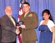 Brig. Gen. Kevin Nally, Department of the Navy deputy chief information officer for the Marine Corps, presents the 2015 Armed Forces Communications Electronics Association Copernicus Award to David Vierra, who is joined by his wife Mila, Feb. 10 in San Diego, Calif. Vierra, an information technology specialist at Marine Corps Tactical Systems Support Activity, received the award for his sustained, superior performance in the field of interoperability and command, control, communications, computers and intelligence/information technology. (U.S. Marine Corps photo by Wil Williams) 