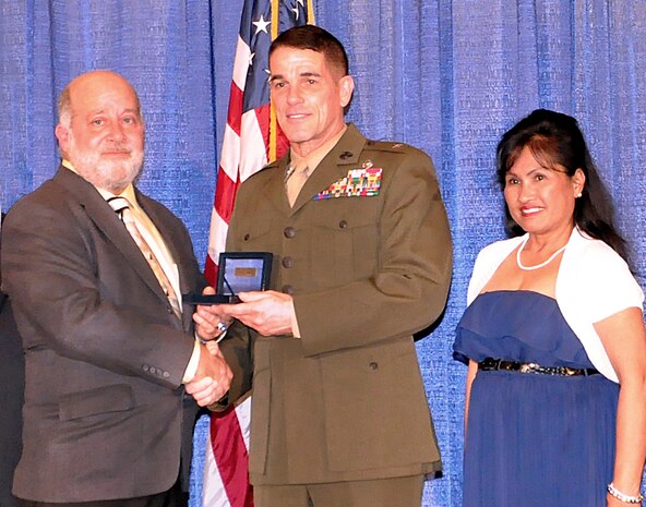 Brig. Gen. Kevin Nally, Department of the Navy deputy chief information officer for the Marine Corps, presents the 2015 Armed Forces Communications Electronics Association Copernicus Award to David Vierra, who is joined by his wife Mila, Feb. 10 in San Diego, Calif. Vierra, an information technology specialist at Marine Corps Tactical Systems Support Activity, received the award for his sustained, superior performance in the field of interoperability and command, control, communications, computers and intelligence/information technology. (U.S. Marine Corps photo by Wil Williams) 