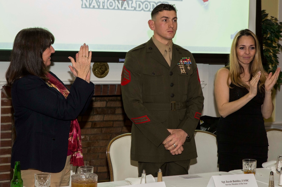 Sgt. Jacob Bublitz, chief instructor for engineer training areas 9 and 10, 2nd Combat Engineer Battalion, 2nd Marine Division, and native of Beaver Dam, Wis., receives applause from members and guests of the Military Affairs Committee, part of the Jacksonville Onslow Chamber of Commerce, after being recognized as the 2014 Service Member of the Year at the Officer’s Club aboard Camp Lejeune, N.C., Feb. 9, 2015. Bublitz was nominated as Service Member of the Month for June 2014, making him eligible to be selected for Service Member of the Year. The award is decided amongst all members of the Armed Forces. (U.S. Marine Corps photo by Cpl. James R. Smith/Released)