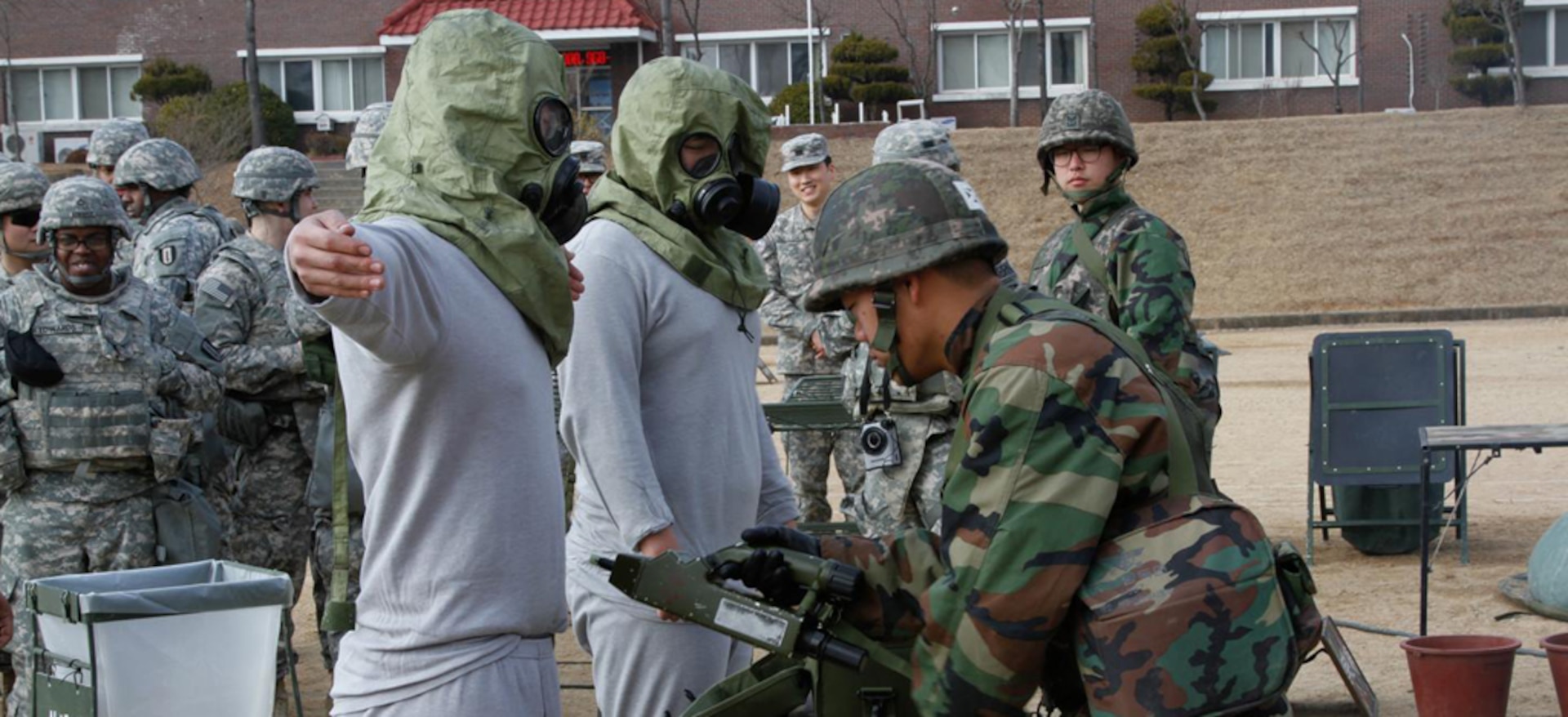 DAEGU, South Korea (Feb. 10, 2015) - Chemical, Biological, Radiological, Nuclear, and Explosives team members from the 50th Infantry Division, Republic of Korea Army, demonstrate proper decontamination clearing procedures for Soldiers, of the 293rd Signal Company, 36th Signal Battalion, 1st Signal Brigade, during a combined decontamination exercise at Base 50, Daegu.  