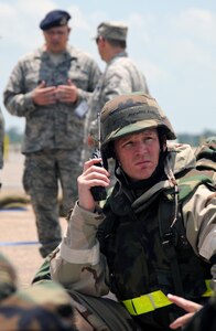 Master Sgt. Michael Ludke, a Nuclear-Biological-Chemical Warfare cell chief from the 123rd Airlift Wing of the Kentucky National Guard, upchannels information during an evacuation of his building following a simulated attack at the Gulfport Combat Readiness Training Center in Gulfport, Miss., May 20, 2010. The 123rd and two other units were being evaluated for wartime readiness as part of an Air Mobility Command Operational Readiness Inspection. The ORI was unique in that it marked the first time inspectors evaluated a unit's performance in defense of the United States, using scenarios that played out on American soil rather than a simulated overseas environment.