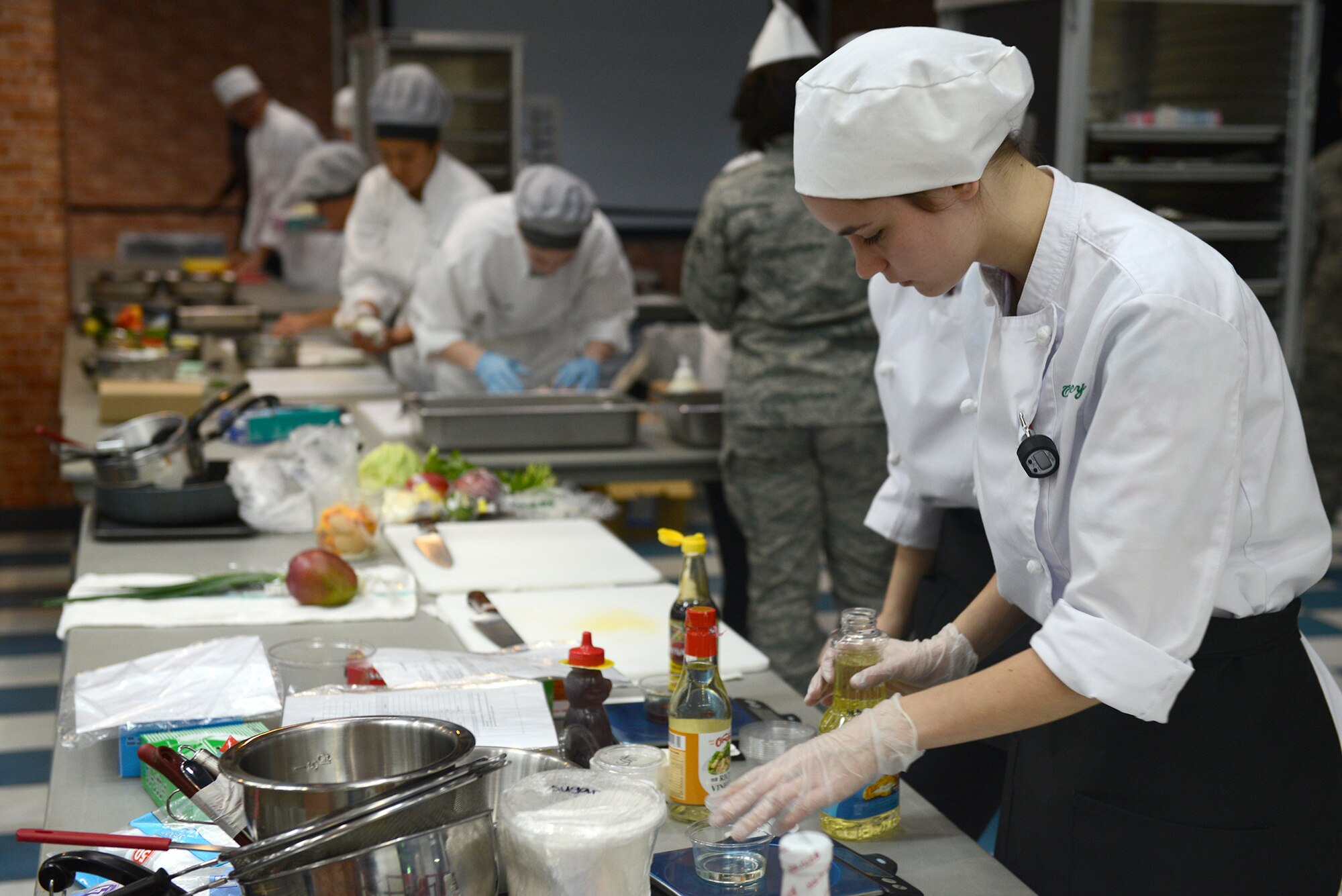 A Kubasaki High School student readies her workstation at Yokota Air Base, Japan, Feb. 5, 2015. Kubasaki is one of six schools within Pacific Air Force to participate in the 2015 Far East Culinary Arts competition which tested teamwork, knife skills, sanitation, menu presentation and the taste of their final product. (U.S. Air Force photo by Airman 1st Class David C. Danford/Released)