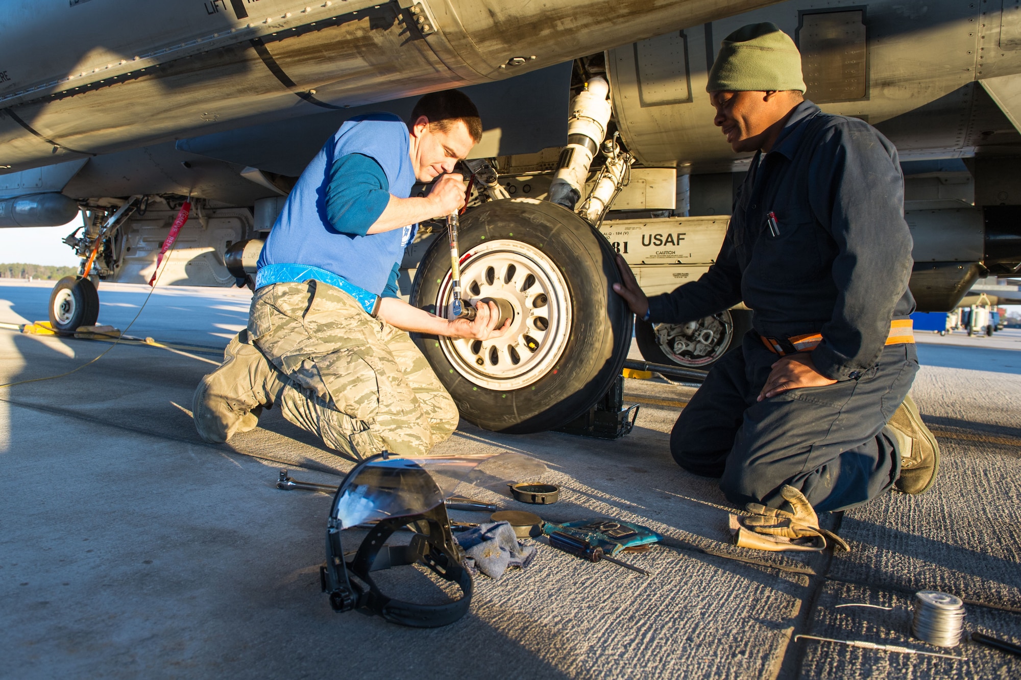 U.S. Air Force Tech. Sgt. Leonard Gajewski and Airman 1st Class Erskine Ham, crew chiefs assigned to the 169th Aircraft Maintenance Squadron, replace a damaged F-16 tire with a new one, Feb. 7, 2015, at McEntire Joint National Guard Base, S.C. Both Airmen are supporting surge flying operations, which encompasses high tempo flying as part of vital training in preparation for deployments. (U.S. Air National Guard photo by Tech. Sgt. Jorge Intriago/Released)