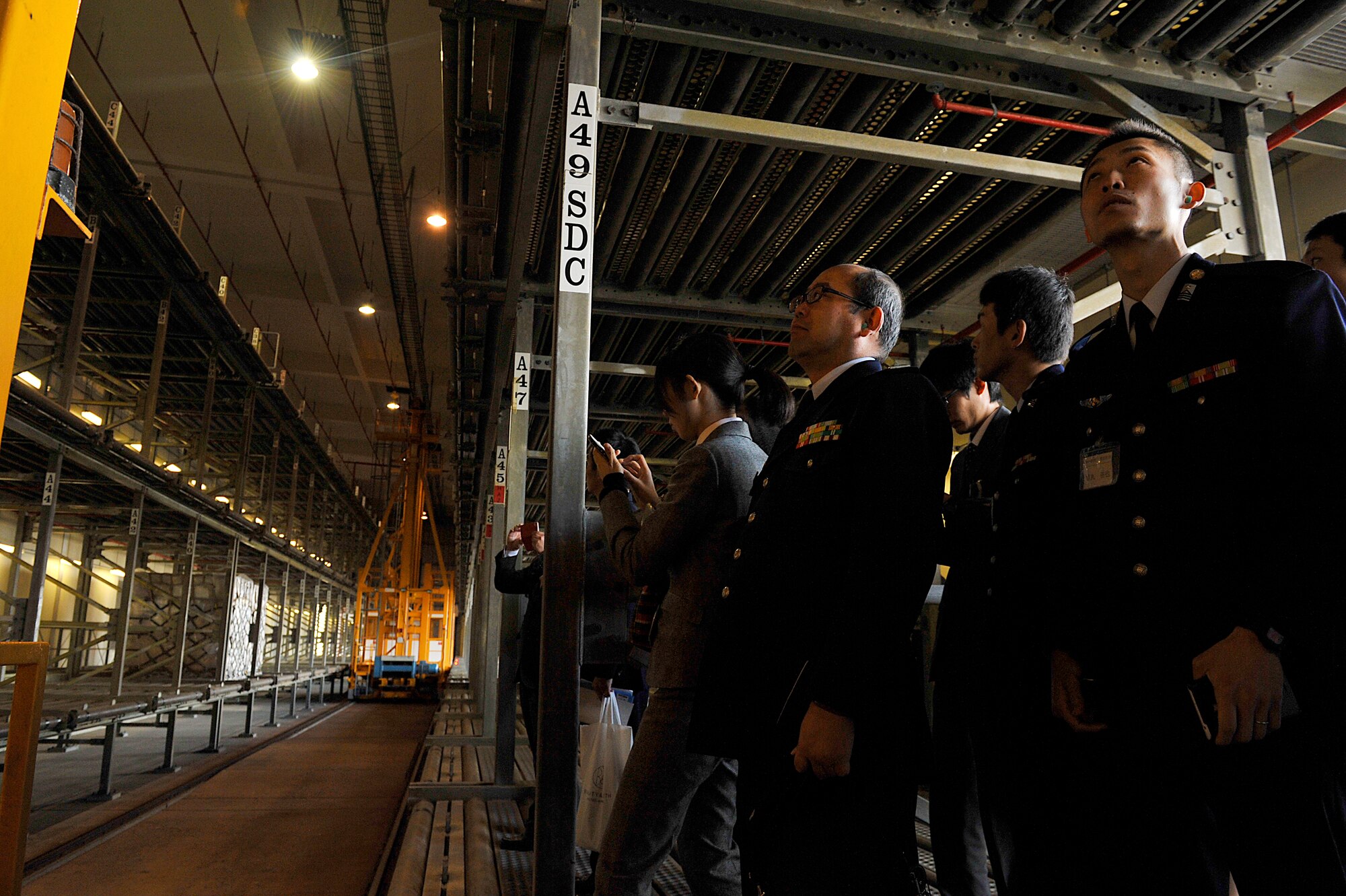 Japan Air Self Defense Force members observe the 733rd Air Mobility Squadron's warehouse during their visit on Kadena Air Base, Okinawa, Japan, Feb. 10, 2015. During these visits, JASDF and U.S. Air Force help to build cooperative relations. It also develops Kadena Airmen, allowing them to network with fellow Airmen from our host nation. (U.S. Air Force photo by Naoto Anazawa)