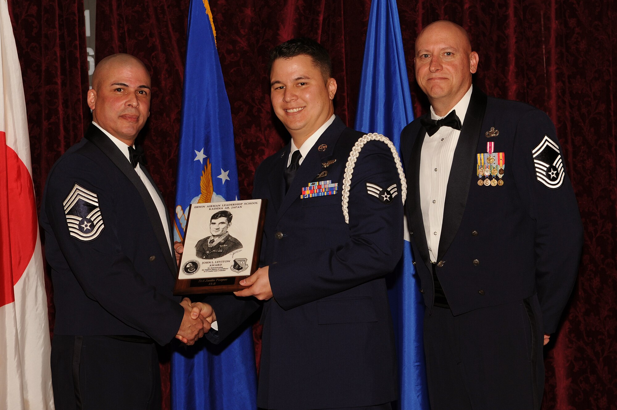 U.S. Air Force Senior Airman Justin Poepoe, 390th Intelligence Squadron intelligence surveillance and reconnaissance scheduling technician, receives the John L. Levitow Award during the Airman Leadership School graduation ceremony on Kadena Air Base, Japan, Feb. 10, 2015. This award is presented to the student who earns the highest average score on evaluations and most embodies the Air Force core values. (U.S. Air Force photo by Airman 1st Class Zade C. Vadnais)