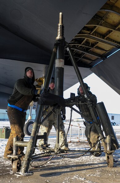 Airmen from the 5th Maintenance Squadron reposition a hydraulic jack under the wing of a B-52H Stratofortress on Minot Air Force Base, N.D., Feb. 4, 2015. The jack is used during a tip gear operation check. Tip gear protects the wings of the aircraft from damage as they flex during landing. (U.S. Air Force photo/Senior Airman Stephanie Morris)