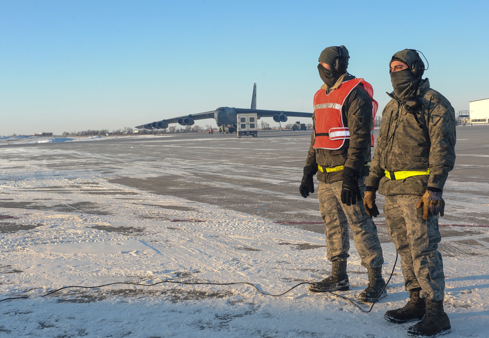 (left) Airman 1st Class Yousef Sakhnini, and (right) Senior Airman Christofer HeltonGomez, 5th Aircraft Maintenance Squadron crew chiefs, observe the engines of a B-52H Stratofortress on Minot Air Force Base, N.D., Feb. 4, 2015. Sakhnini and HeltonGomez ensures all systems are operating properly before the aircraft takes off. (U.S. Air Force photo/Senior Airman Stephanie Morris)