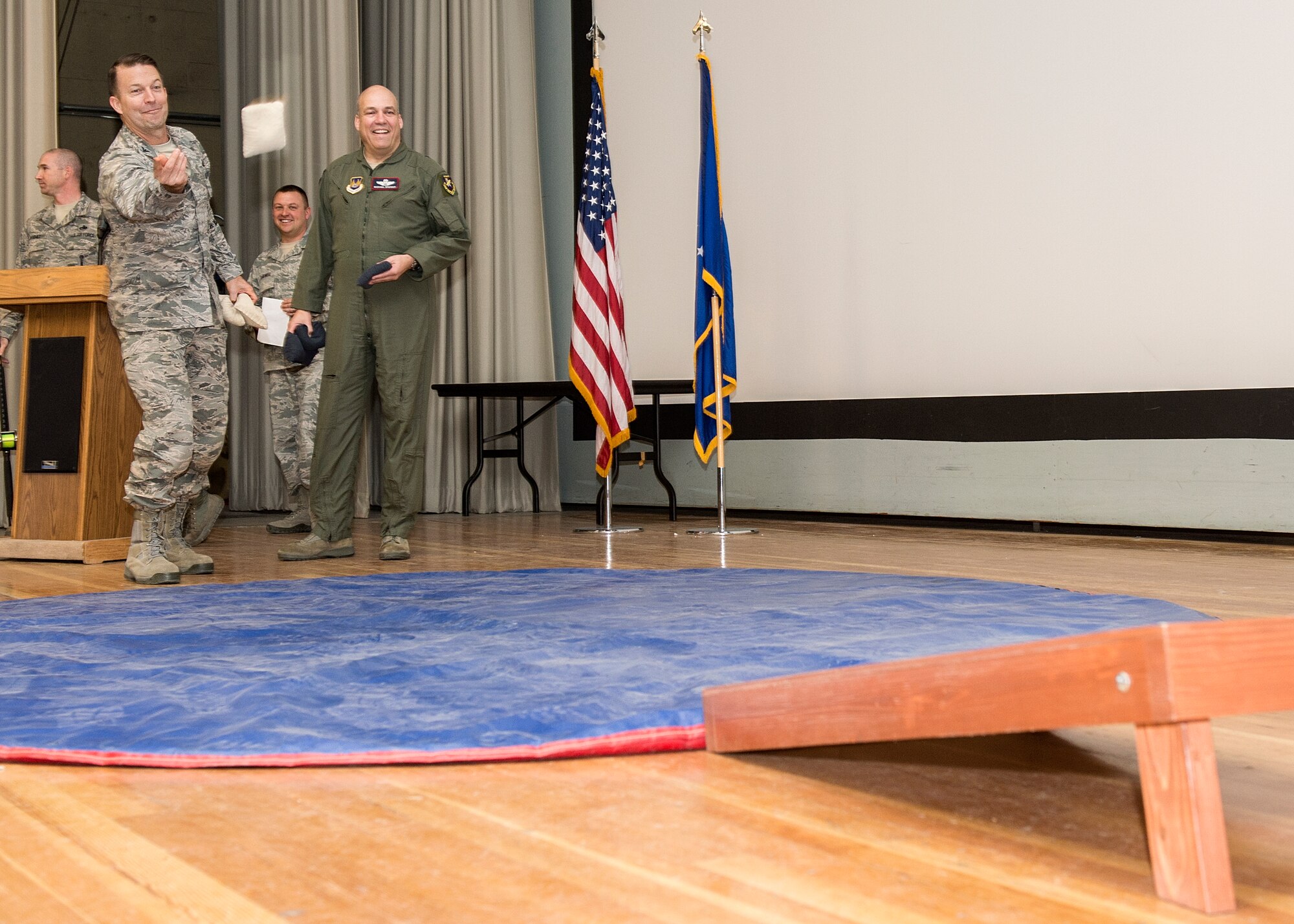 From left: Col. Eric Leshinsky, 412th Mission Support Group commander, tosses a bean bag while Brig. Gen. Michael T. Brewer, 412th Test Wing commander, looks on during the 412th TW's fourth quarter award ceremony Feb. 6 in the base theater. (U.S. Air Force photo by Edward Cannon)