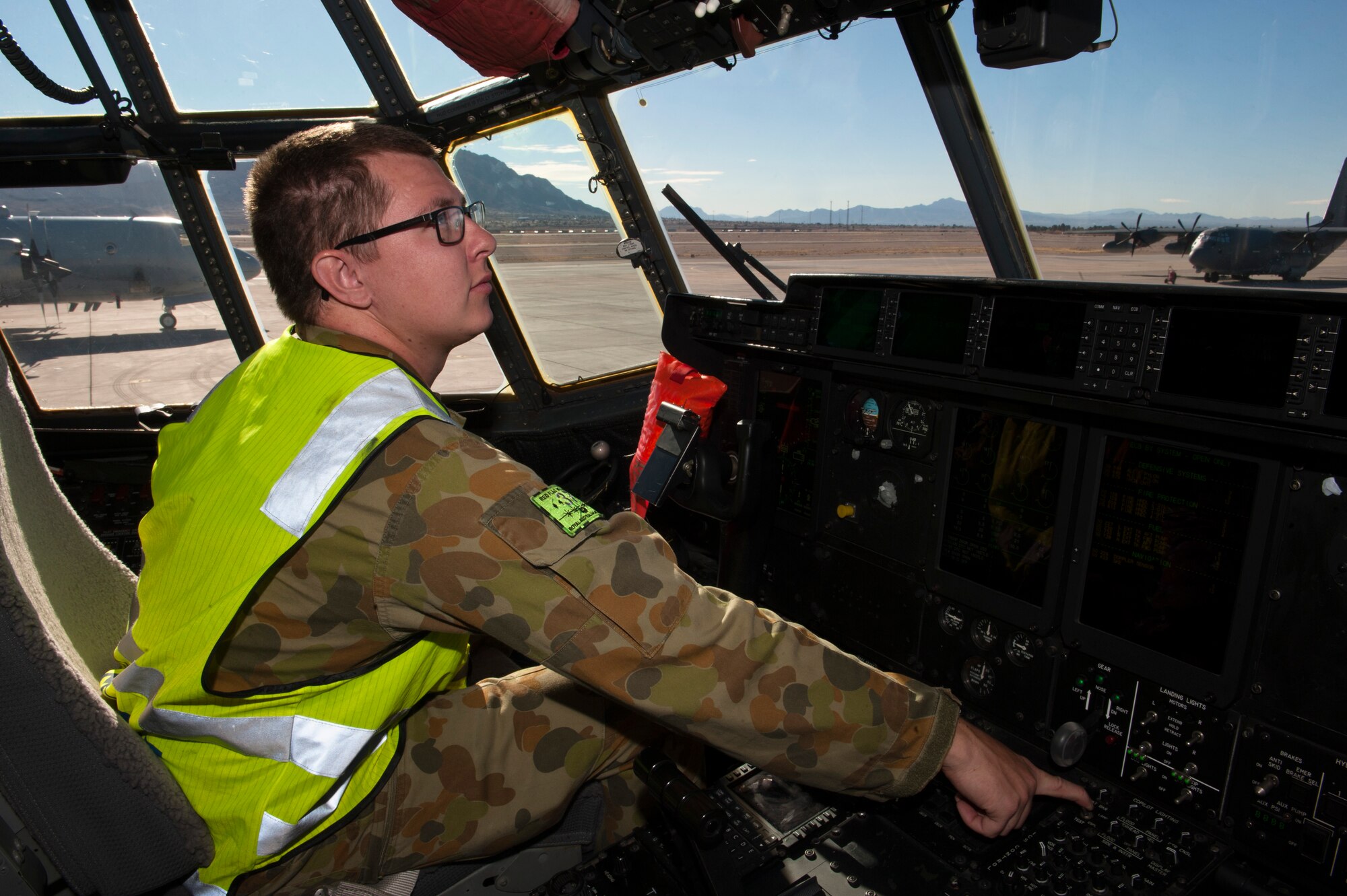 A Royal Australian air force aircraft maintainer prepares a C-130J Super Hercules from 37 Squadron, Richmond, Australia, for a training exercise during Red Flag 15-1 at Nellis Air Force Base, Nev., Feb. 7, 2015. In addition to increasing aircrew combat skills, Red Flag also increases ground crew combat readiness and effectiveness. (U.S. Air Force photo by Senior Airman Thomas Spangler)