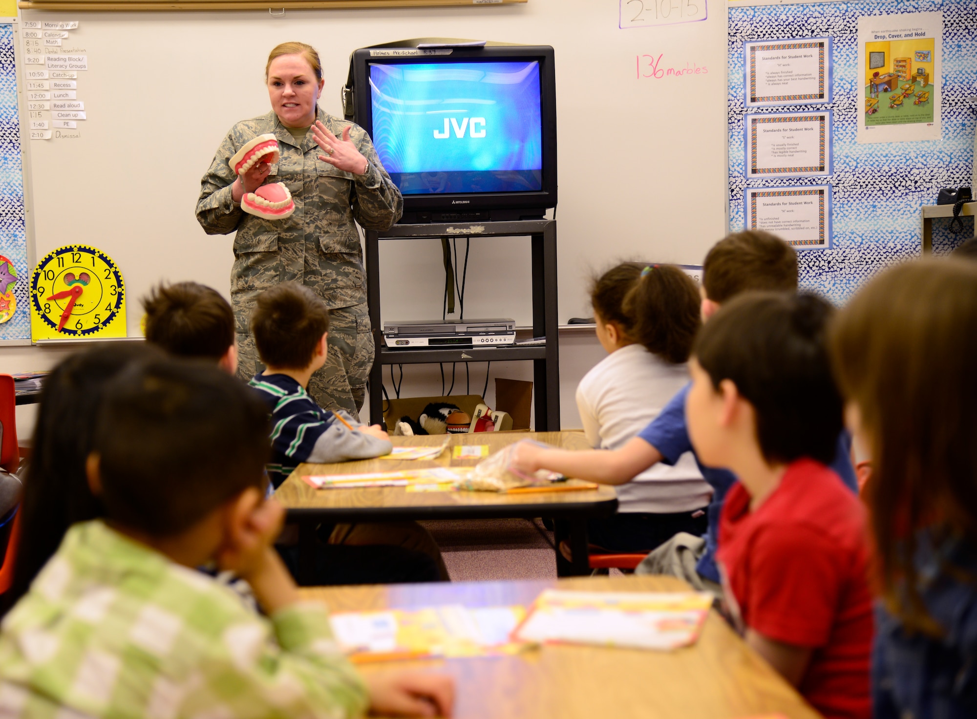 U.S. Air Force Staff Sgt. Amber Green, the 354th Medical Operations Squadron dental records noncommissioned officer in charge, talks to children during a National Children’s Dental Health month demonstration at Anderson Elementary, Eielson Air Force Base, Alaska, Feb. 10, 2015. Icemen from the dental office explained the importance of staying away from sugary foods, eating a healthy diet, how toothpaste is a vitamin for teeth and gave brushing and flossing techniques. (U.S. Air Force photo by Senior Airman Racheal E. Watson/Released)