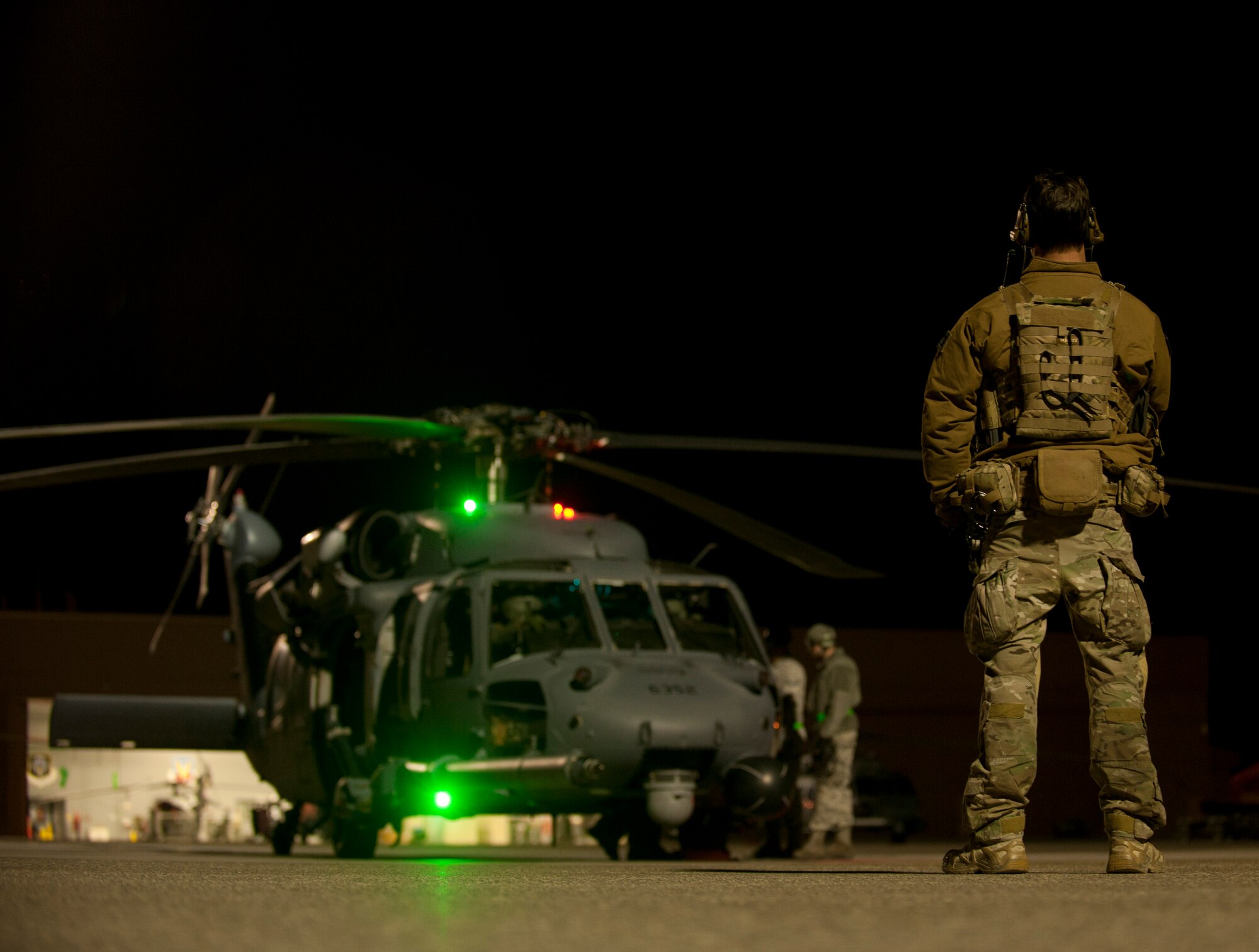 A Pararescueman assigned to the 48th Rescue Squadron, Davis-Monthan Air Force Base, Ariz., looks on as an HH-60G Pave Hawk assigned to the 66th Rescue Squadrongoes through final preparations prior to executing a Red Flag 15-1 personnel recovery training mission at Nellis Air Force Base, Nev., Feb. 5, 2015. Pararescuemen provide emergency medical treatment necessary to stabilize and evacuate injured personnel while acting in an enemy-evading recovery role. (U.S. Air Force photo by Airman 1st Class Joshua Kleinholz)