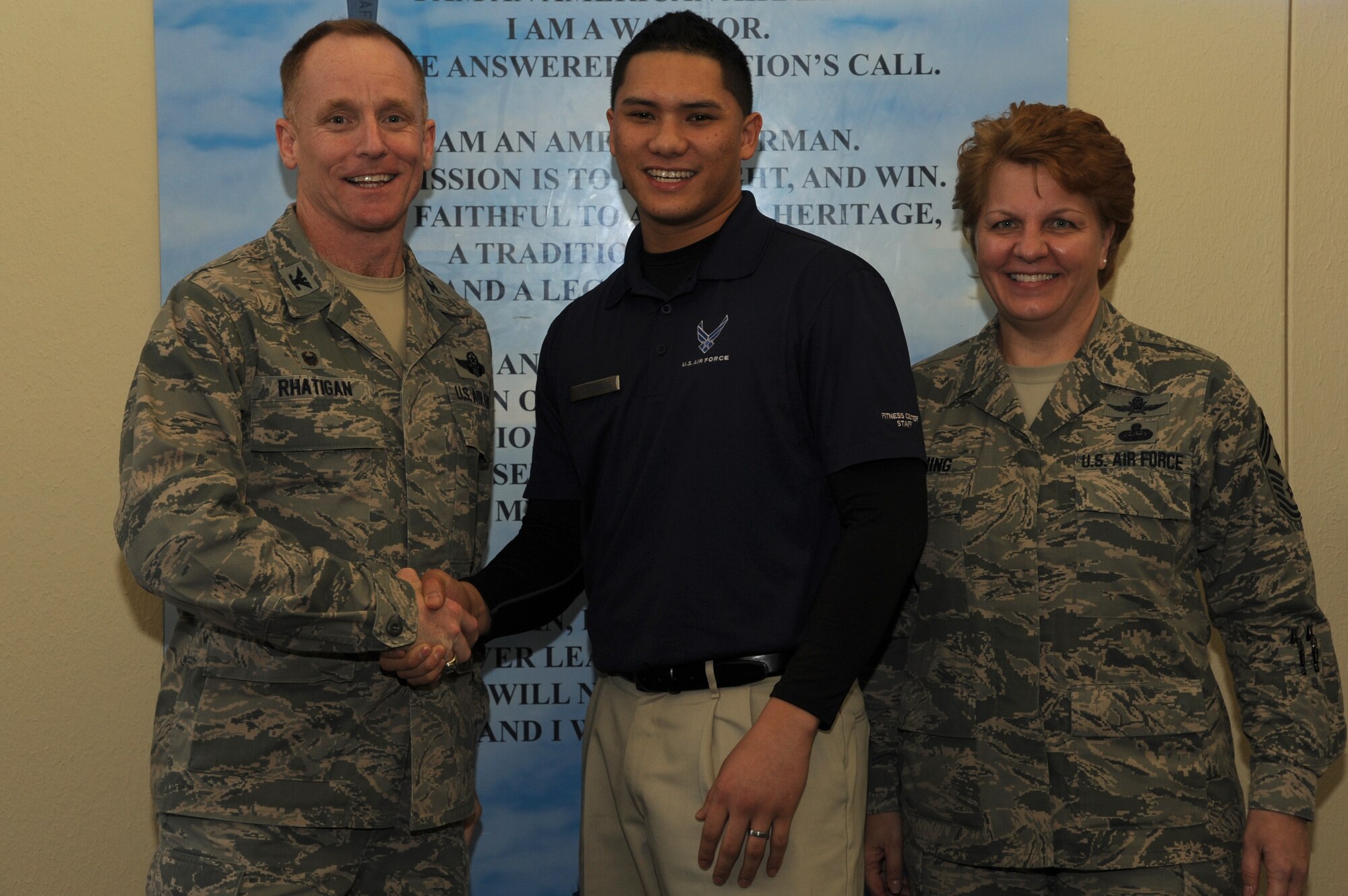 Col. Patrick Rhatigan, the 19th Airlift Wing commander, along with Chief Master Sgt. Rhonda Buening, the 19th AW command chief, congratulate Senior Airman Frederick Burgos, a 19th Force Support Squadron fitness specialist, for his selection as Combat Airlifter of the Week Feb. 9, 2015, at Little Rock Air Force Base, Ark. Burgos, a Yuba City, Calif., native, orchestrates the base sports program by coordinating 46 units sports representatives and by managing the $43,000 official sports contract. (U.S. Air Force photo by Airman 1st Class Mercedes Muro) 