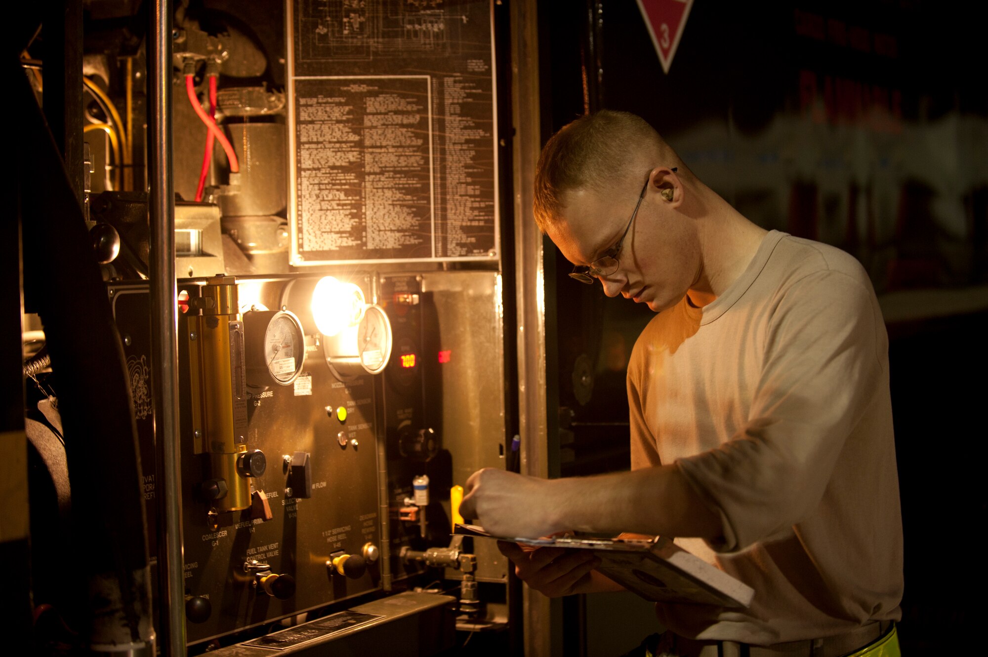 Staff Sgt. Nicholas Flamm, a fuels specialist assigned to the 509th Logistics Readiness Squadron at Whiteman Air Force Base, Mo., annotates fuel delivery data while servicing aircraft prior to Red Flag 15-1 night training sorties at Nellis AFB, Nev., Feb. 4, 2015.  Aircraft maintenance continues throughout the night to ensure aircrews continue to receive an effective, but most of all safe, training experience. (U.S. Air Force photo by Airman 1st Class Joshua Kleinholz)