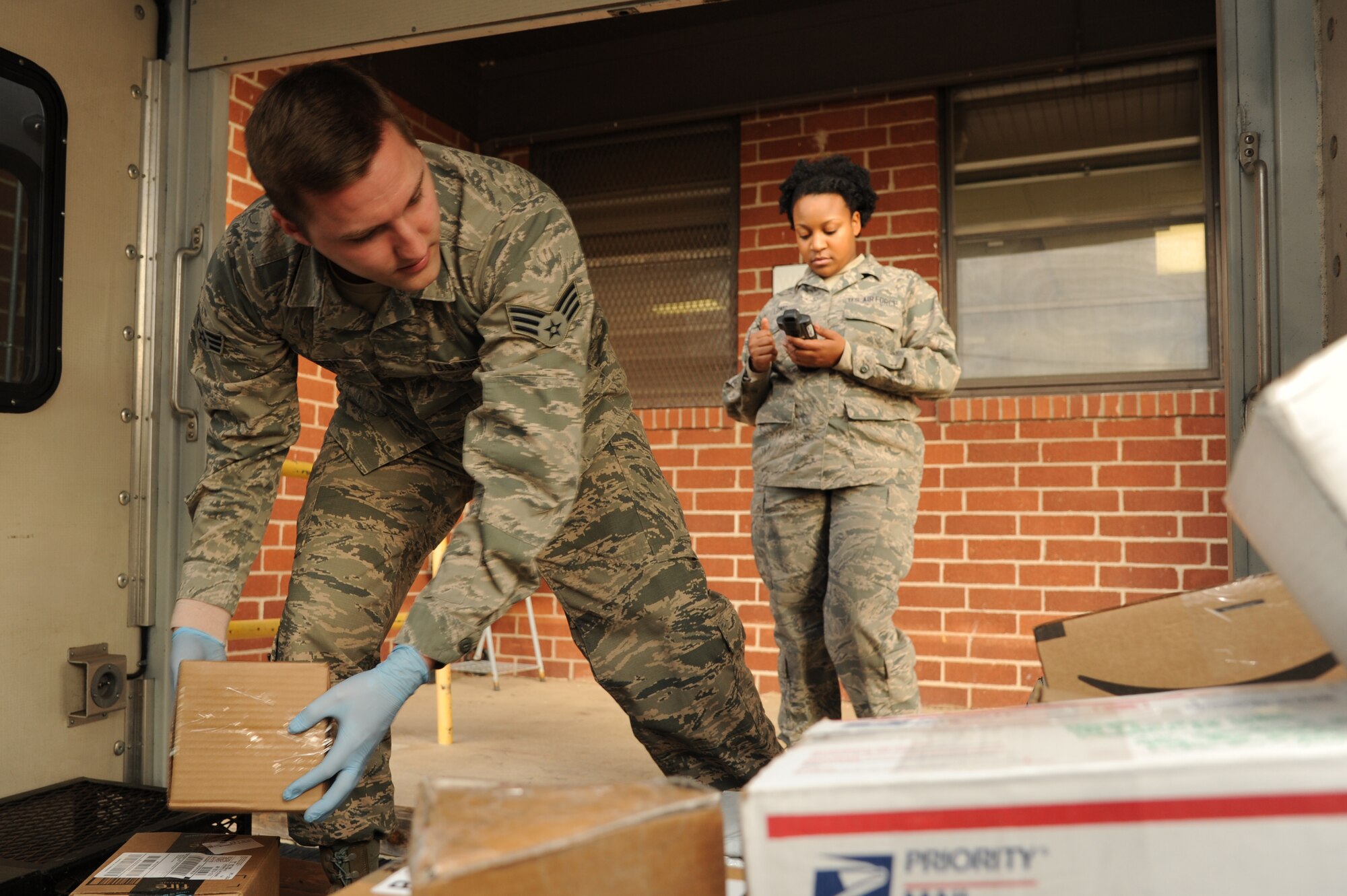 Senior Airman William Heebsh and Senior Airman Jessica Long, 19th Communications Squadron official mail clerks, prepare packages to be delivered to the base populous Jan. 20, 2015, at Little Rock Air Force Base, Ark. Along with packages, scanners are also prepared for recipients to sign once their packages have been delivered. (U.S. Air Force photo by Airman 1st Class Mercedes Muro) 